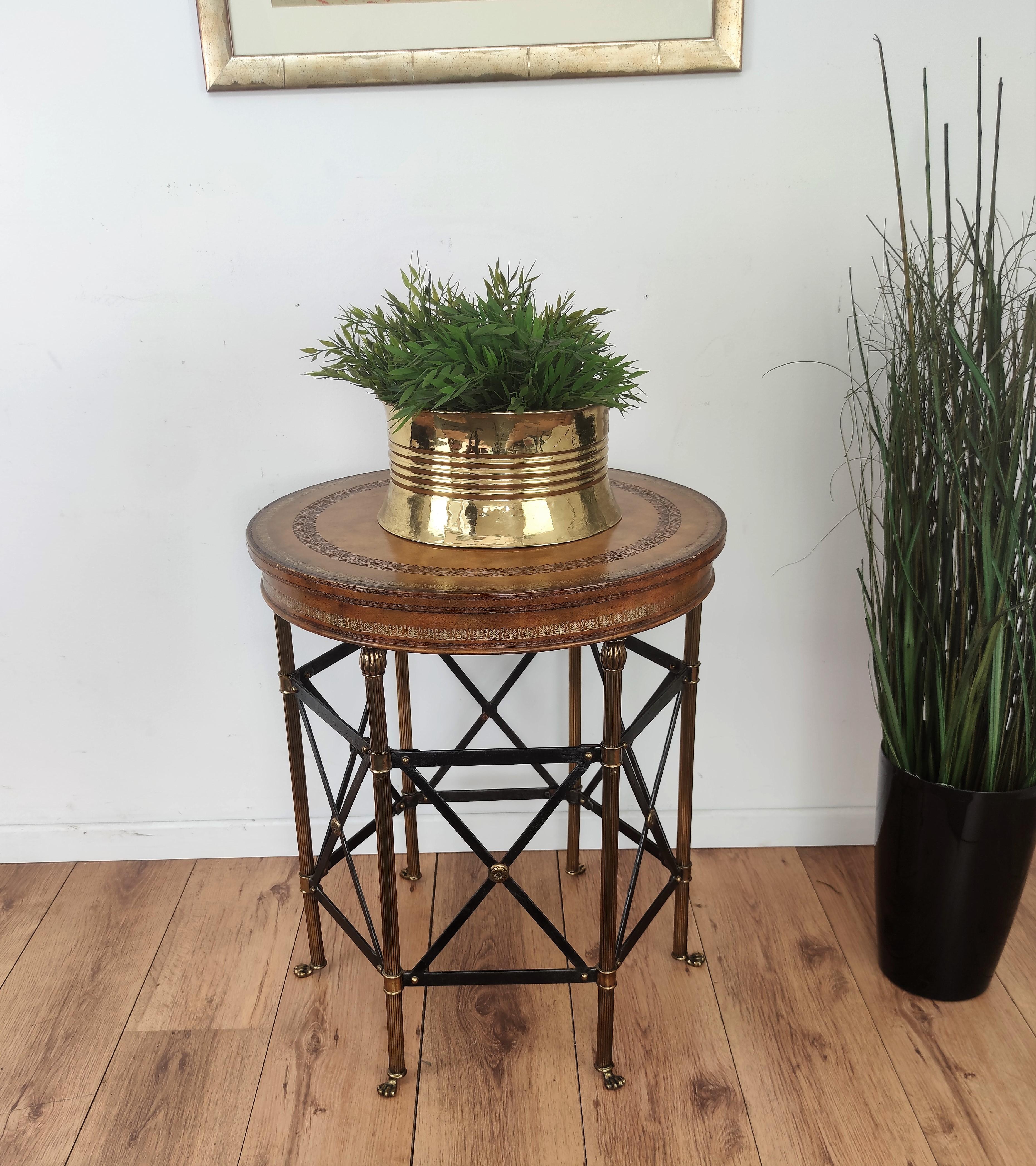 Elegant and complete leather wrapped center table or side table having tooled leather top, standing on a beautiful brass legs connected in a metal hexagonal shape and terminated in great brass foot end casters.