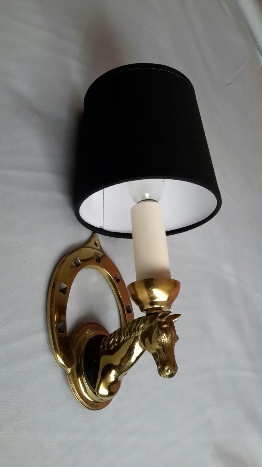 Elegant single sconce of the 1950s by the famous Parisian Maison Lancel, in gilded bronze with black patina figuring a head and a horseshoe.

The sconce is in a excellent condition. The electric part has been renewed and fits the US standards.