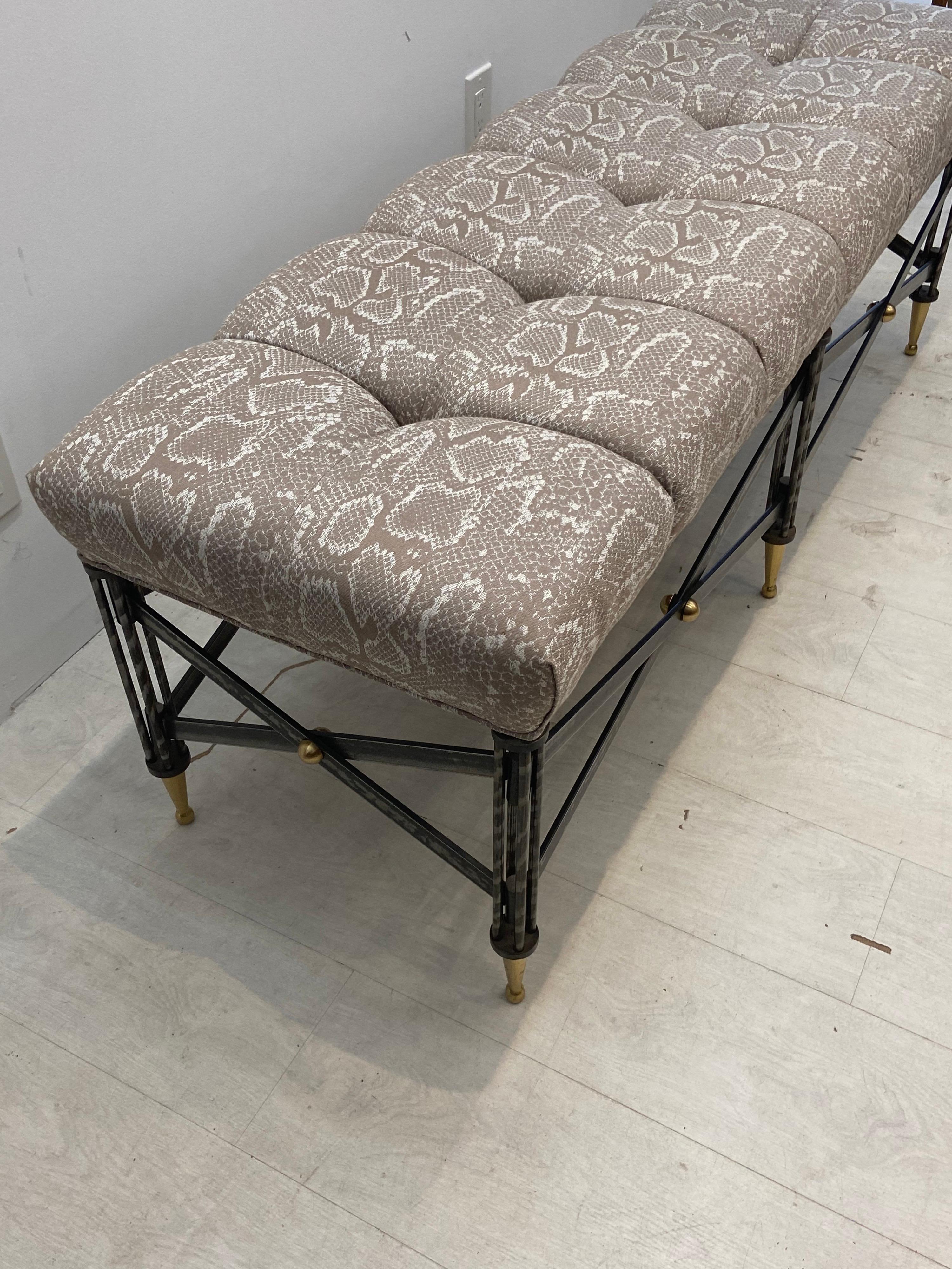 Neoclassical iron bench with brass feet. Upholstered top fabric in very good condition. 56 wide 19 deep 20 inches high.