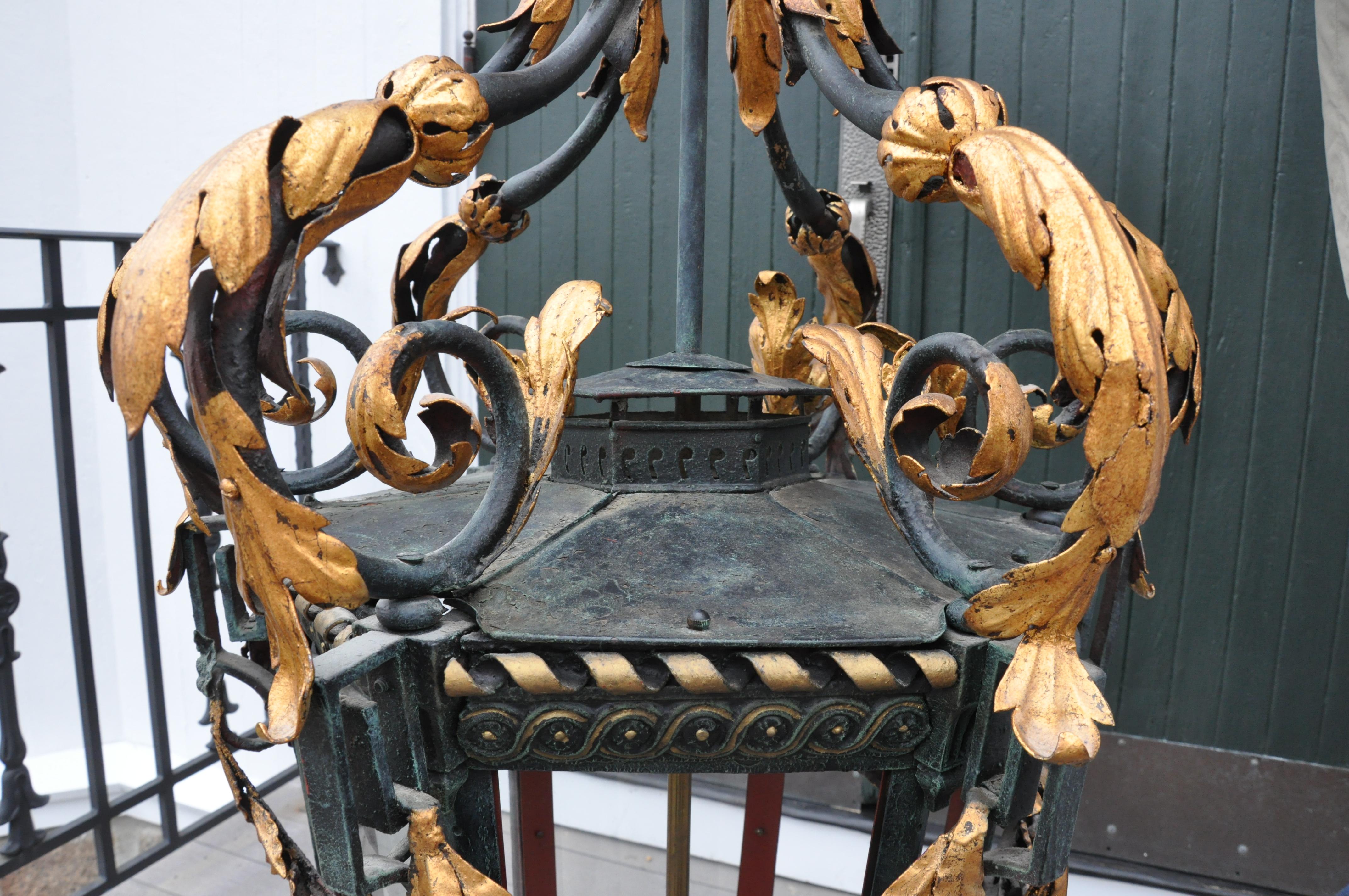 Monumental neoclassical hall or exterior lantern, circa 1900.

-- Painted tole and iron, hand wrought, gilt foliates and laurel swags
-- Wired to modern standards.