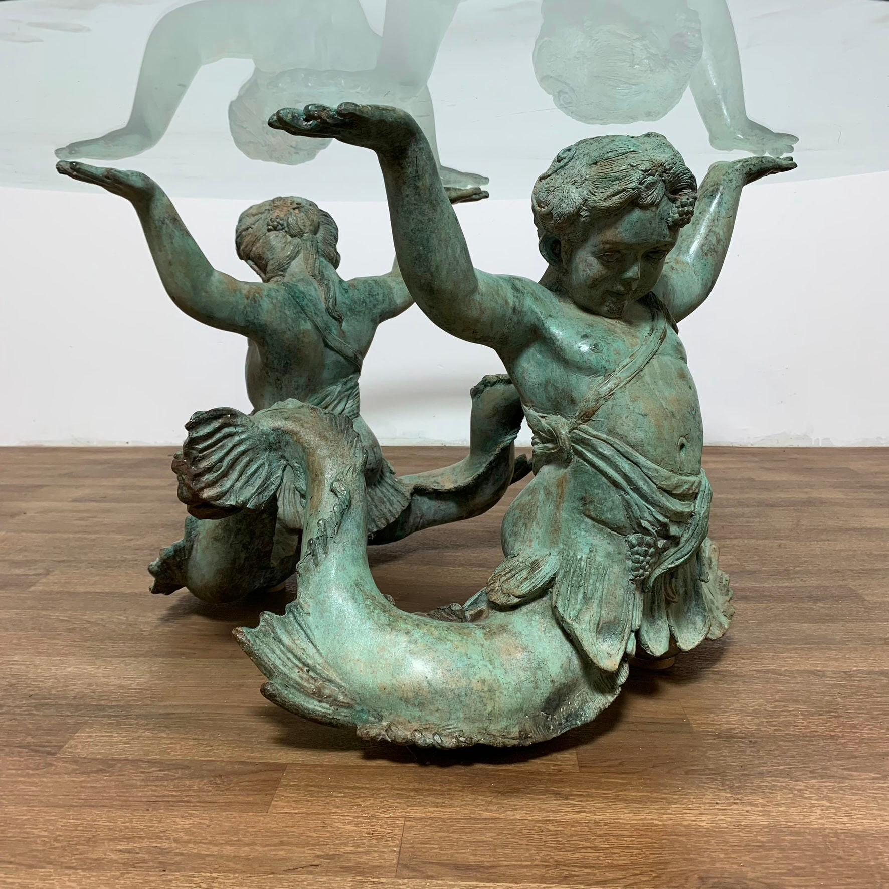 A neoclassical Italian bronze putti di mare (angels of the sea) coffee table with beveled glass top, ca 1970s,
