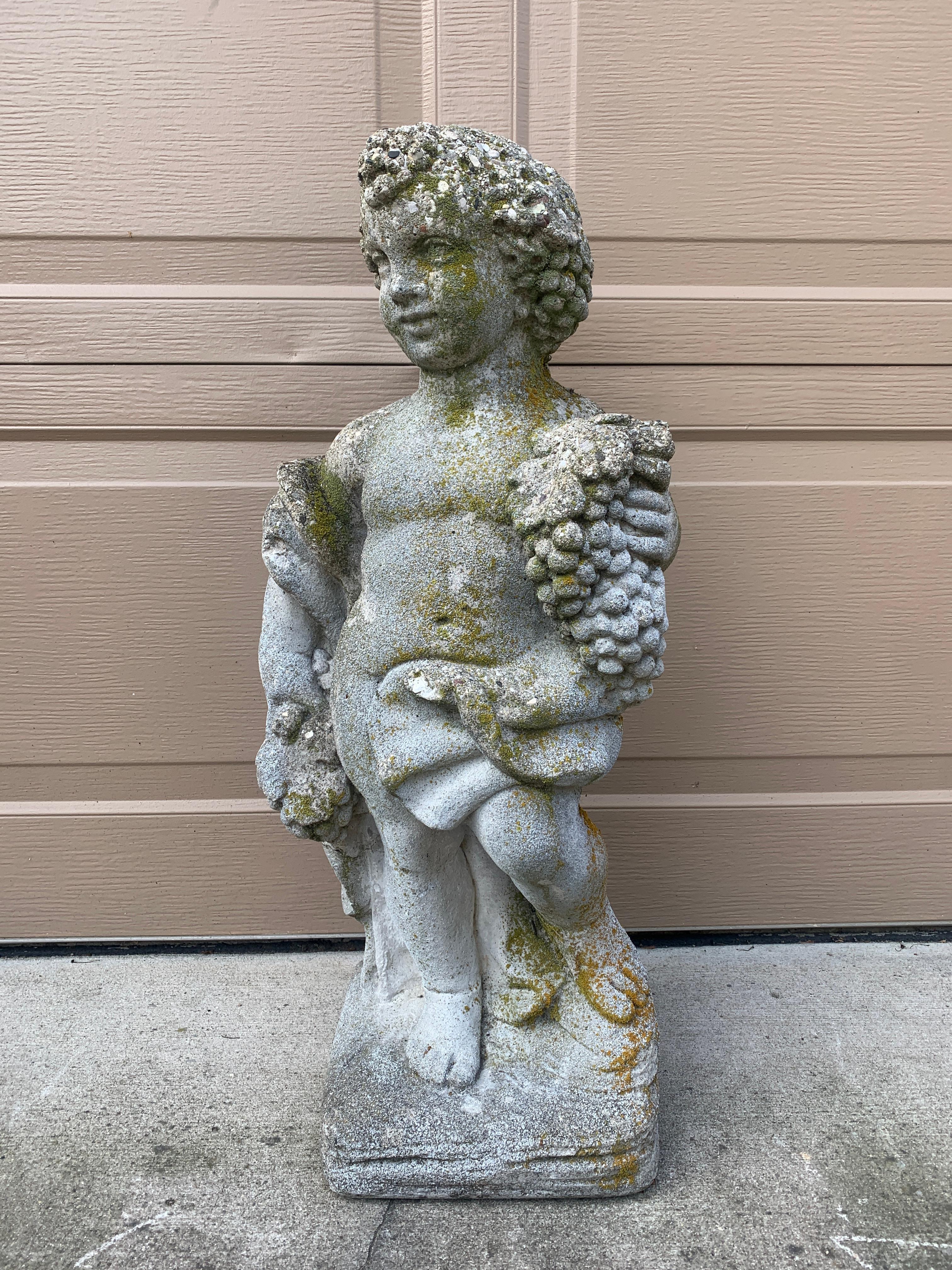 Eine atemberaubende Statue aus Steinguss mit einem drapierten Cherub oder einer Putte, die Weintrauben hält. Diese allegorische Statue erinnert an Bacchus, den Gott des Weines. Das Stück ist der perfekte Akzent in einem Garten. 

USA, Ende des 20.