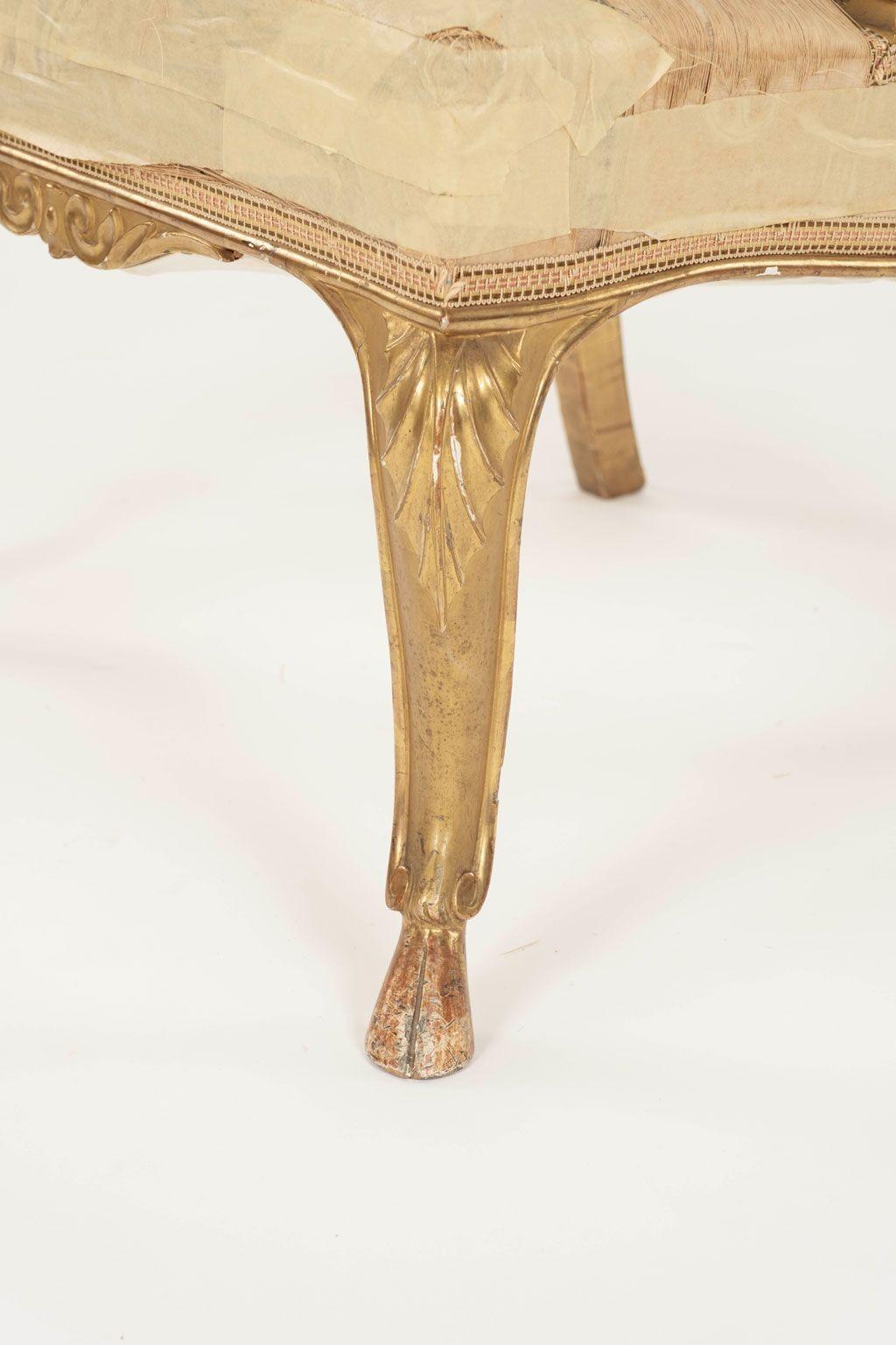 Neoclassical Italian giltwood slipper chair circa 1810. Masterfully hand-carved and gilded slipper chair with cabriole legs raised upon hoof feet. Upholstered in original - or very early - tattered yellow silk tapestry. Sturdy and stable.