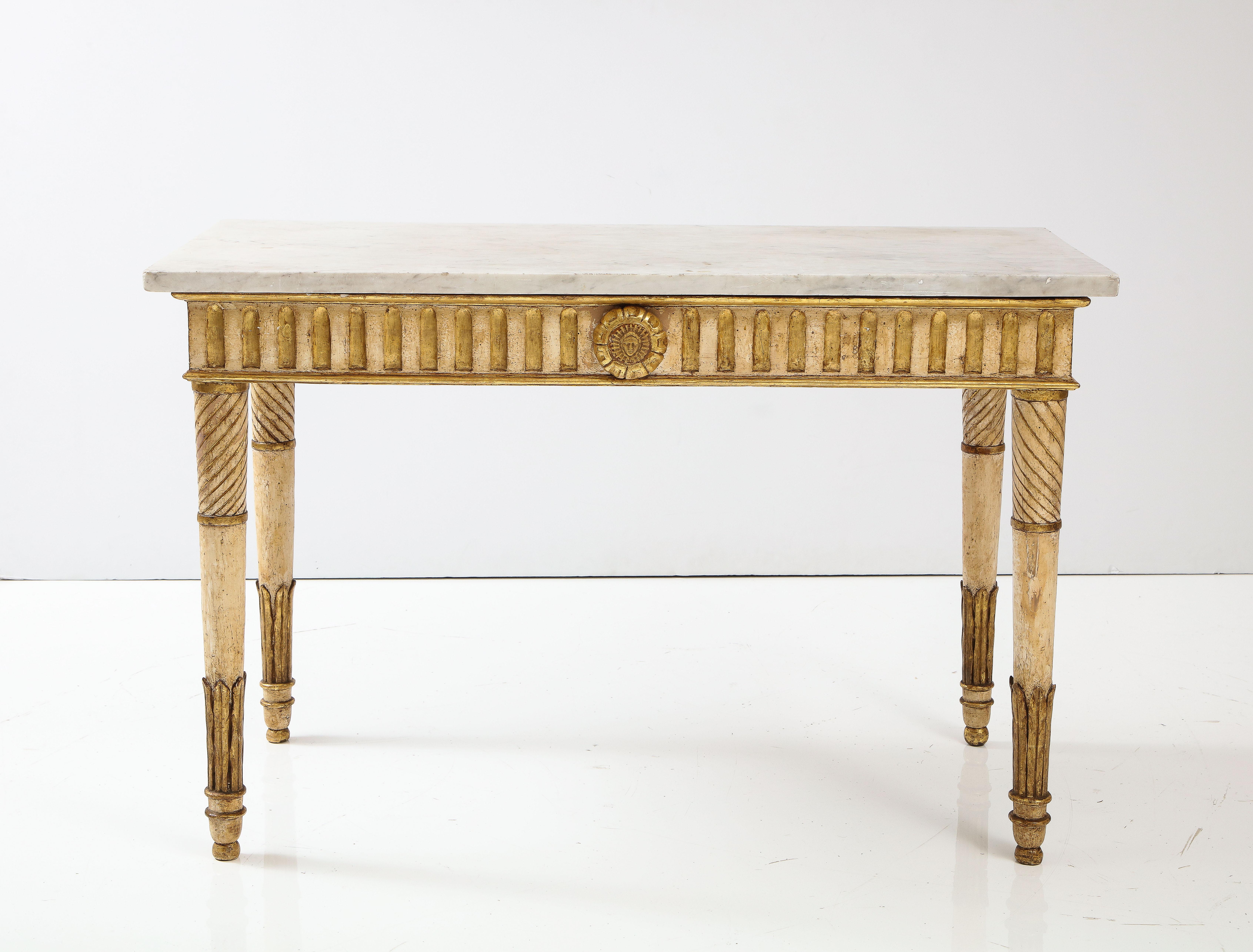 An exquisite and extremely elegant Italian 18th century Louis XVI period carved, painted and gilded wood Neoclassical console table, with original Carrara white marble top. The freestanding console is raised by circular tapered legs with acanthus