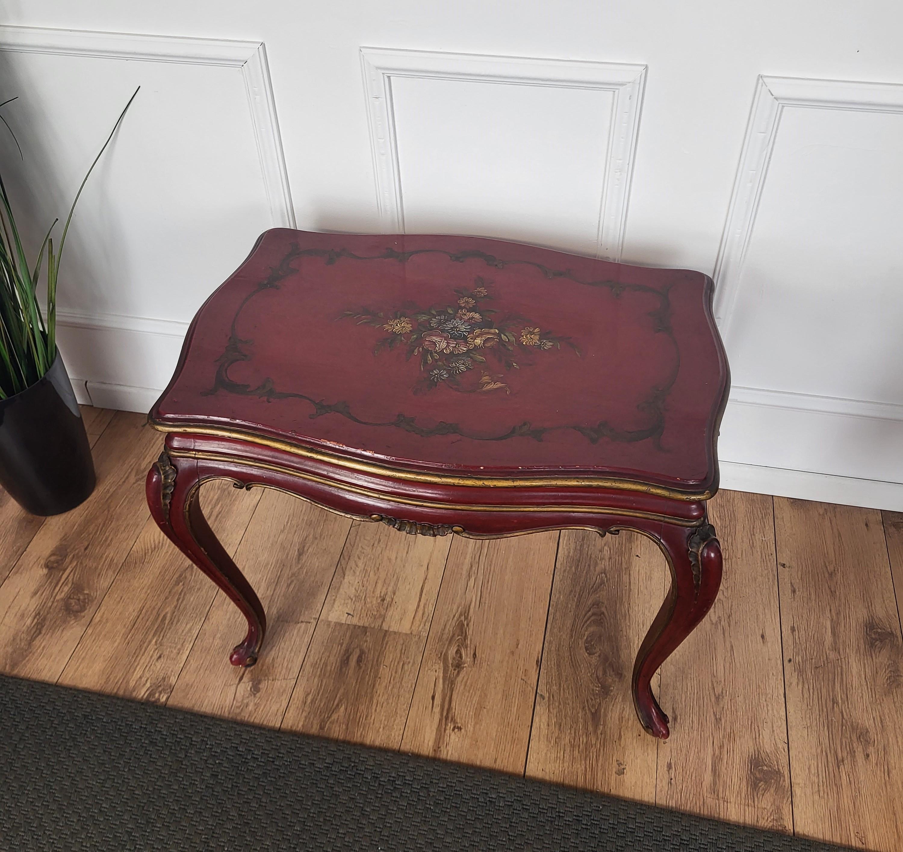 A beautiful Italian Walnut side table with great details and red bordeaux painted and carved shaped frame side with golden details. The beautiful top painted decors are classic figures in chinoiserie style. A very special, elegant, modern and