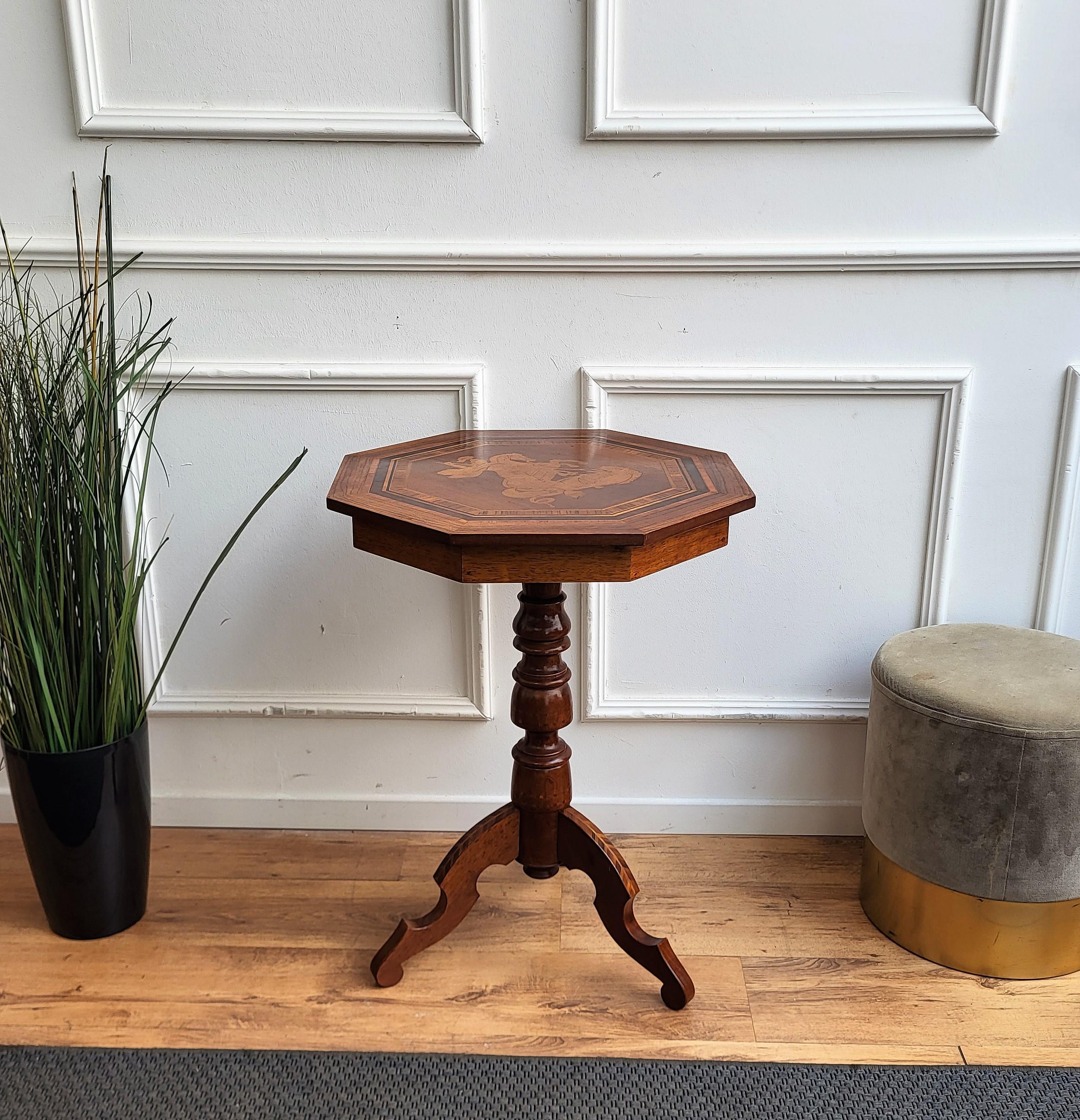 A beautiful Italian Walnut octagonal side table with great details and frames shaped in Victorian, Napoleon III, Louis XV style with beautiful inlay decors in classic figures on the top and all around the tripod feet legs. A very elegant, modern and