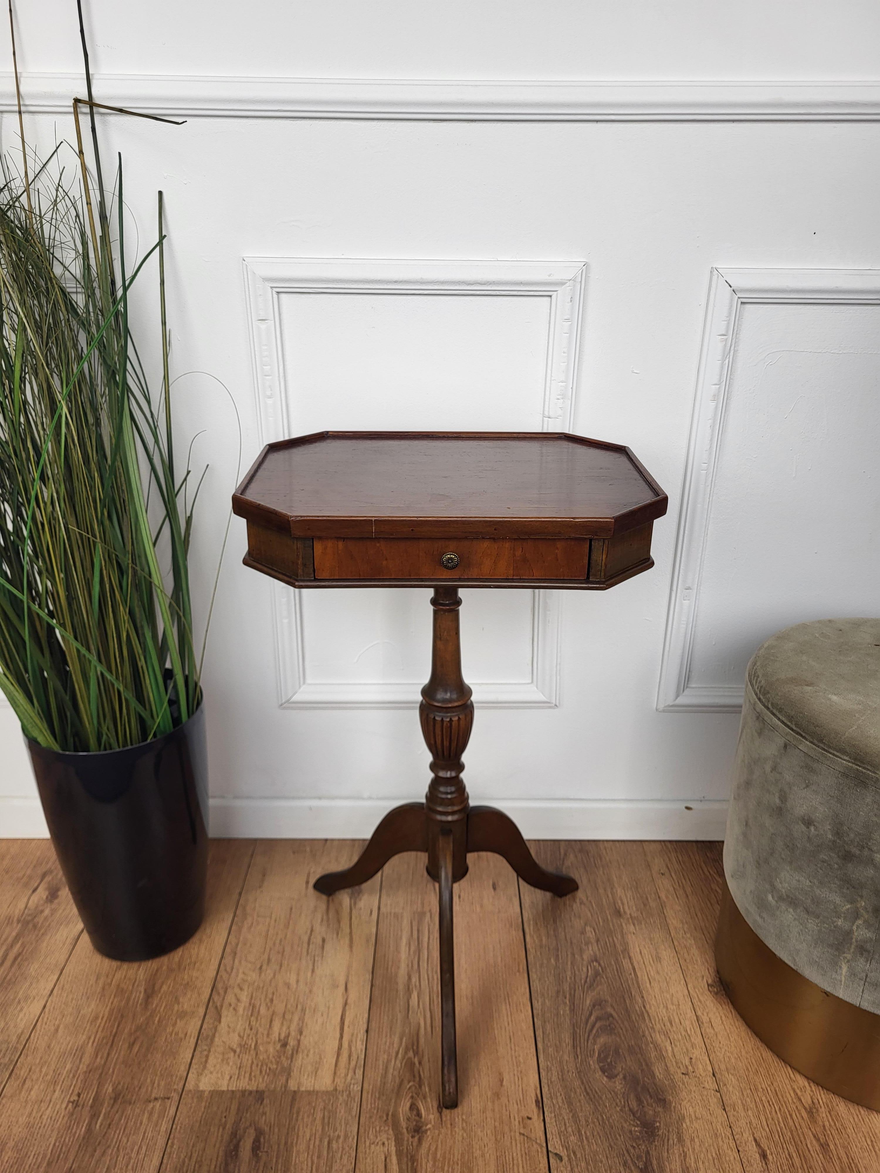 A beautiful Italian Walnut octagonal side table with great details and frames shaped in Victorian, Napoleon III, Louis XV style with front drawer and the tripod feet legs. A very elegant, modern and classic piece that showcases the refined