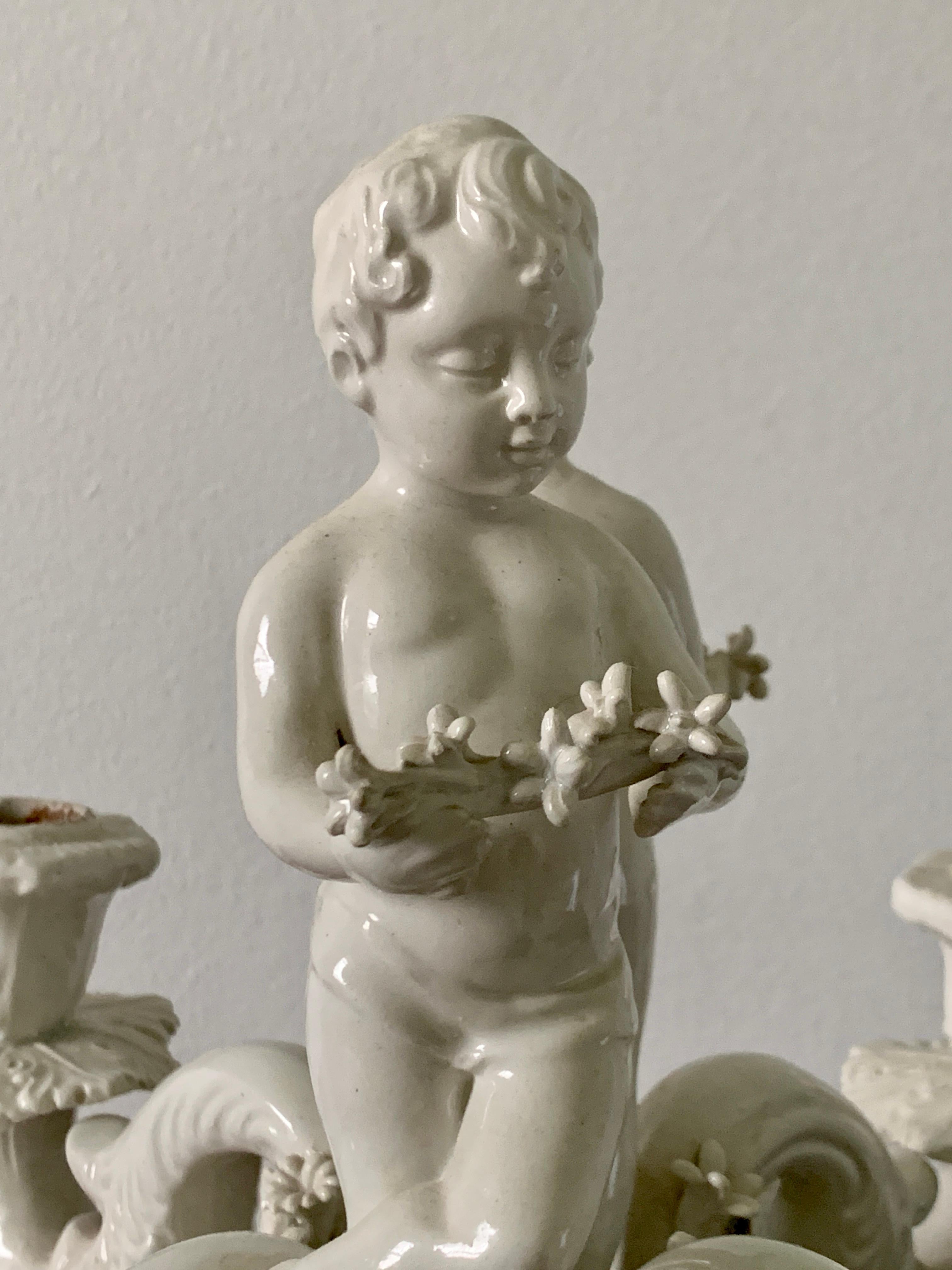 A beautiful vintage porcelain 4-arm candelabra featuring two putti back to back holding floral garlands. 

Italy, Mid-20th Century

Measures: 10.25