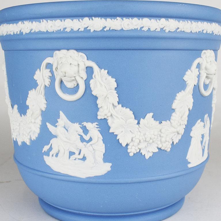 Wedgwood jardinare or cachepot with an applied cream neoclassical design on a light blue “Wedgwood Blue” background. A fabulous piece to display plants or flowers. The body features 5 mini Greek mythological scenes in cream framed by lion heads with