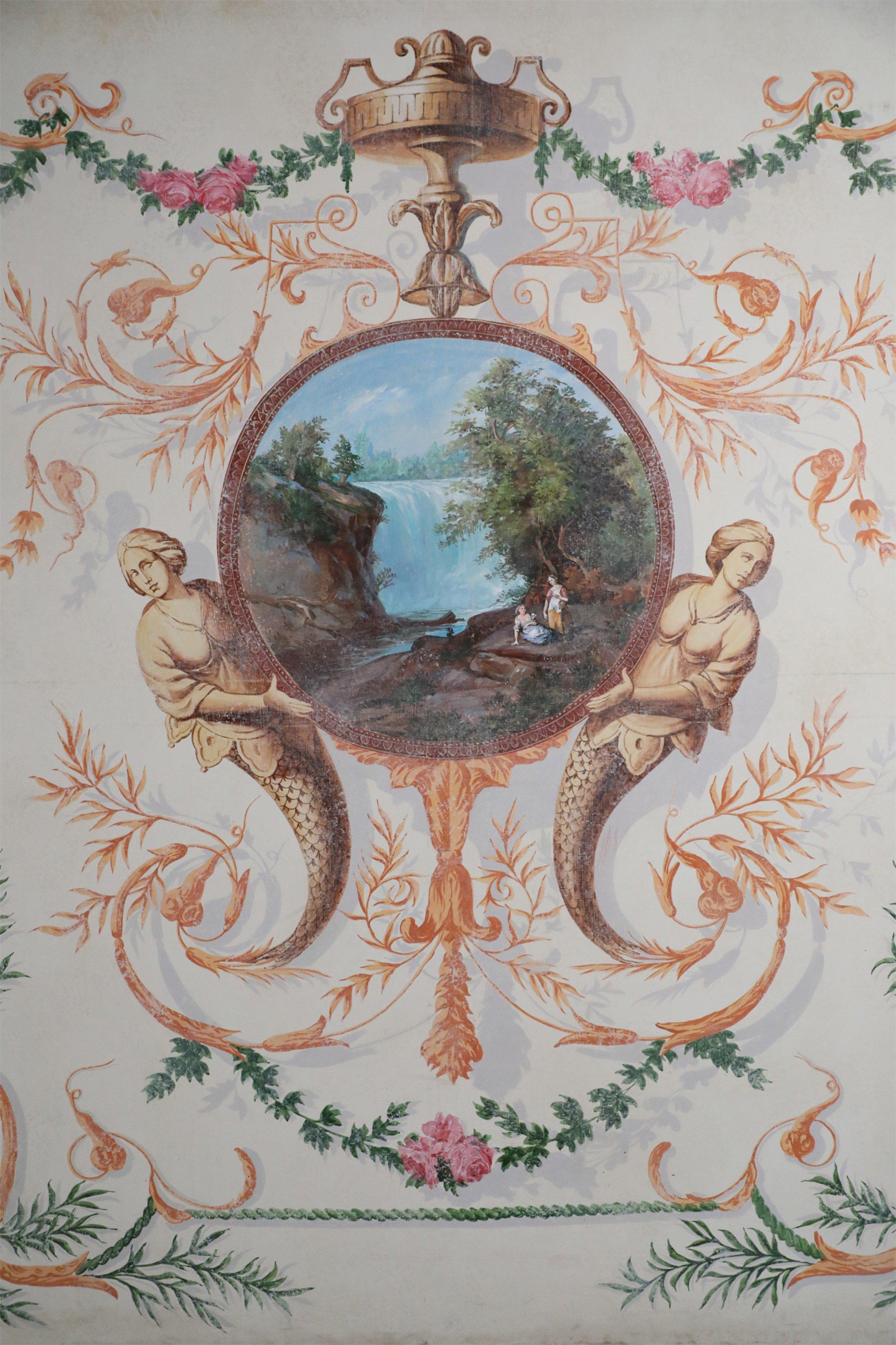 Peinture acrylique vintage de style néoclassique (20e siècle) présentant une scène centrale de paysage circulaire avec deux femmes près d'une cascade, tenues par deux sirènes et une bordure feuillue ombragée élaborée de feuilles, de fleurs et