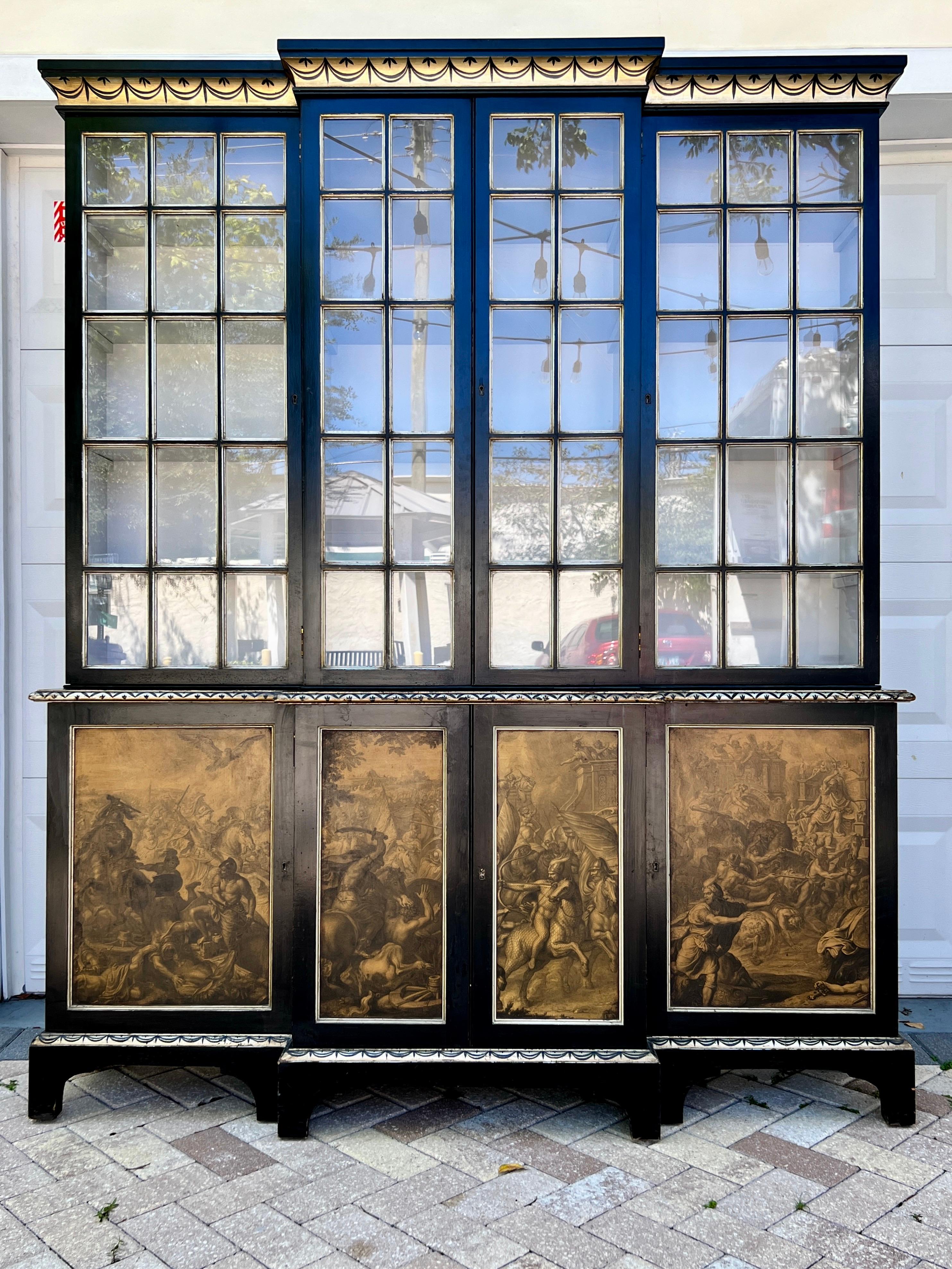 Bibliotheque display cabinet hand painted in black with Neoclassical motifs in silver and gold leaf. The breakfront is fitted with glass pane cabinet doors with antique silver leaf trim. The doors open to five rows of interior shelves painted in