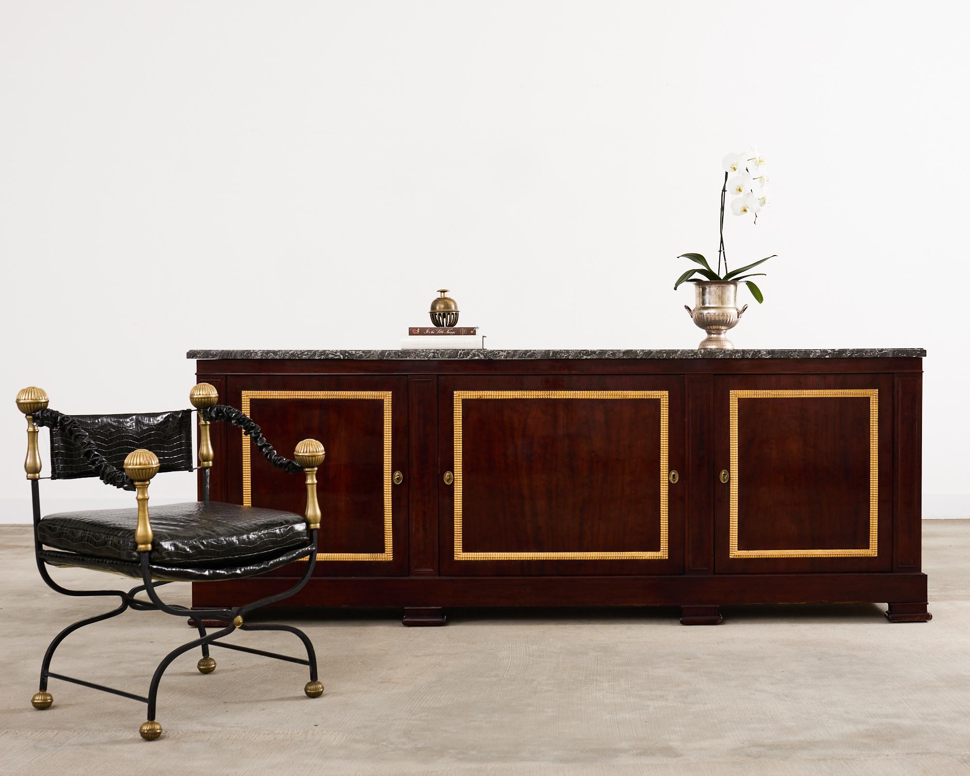 Imposant buffet en acajou du XIXe siècle, réalisé dans le style néoclassique de Louis Philippe. L'armoire est constituée d'un épais boîtier en acajou massif qui présente des veines d'acajou rayonnantes avec une finition polie riche et foncée. Le