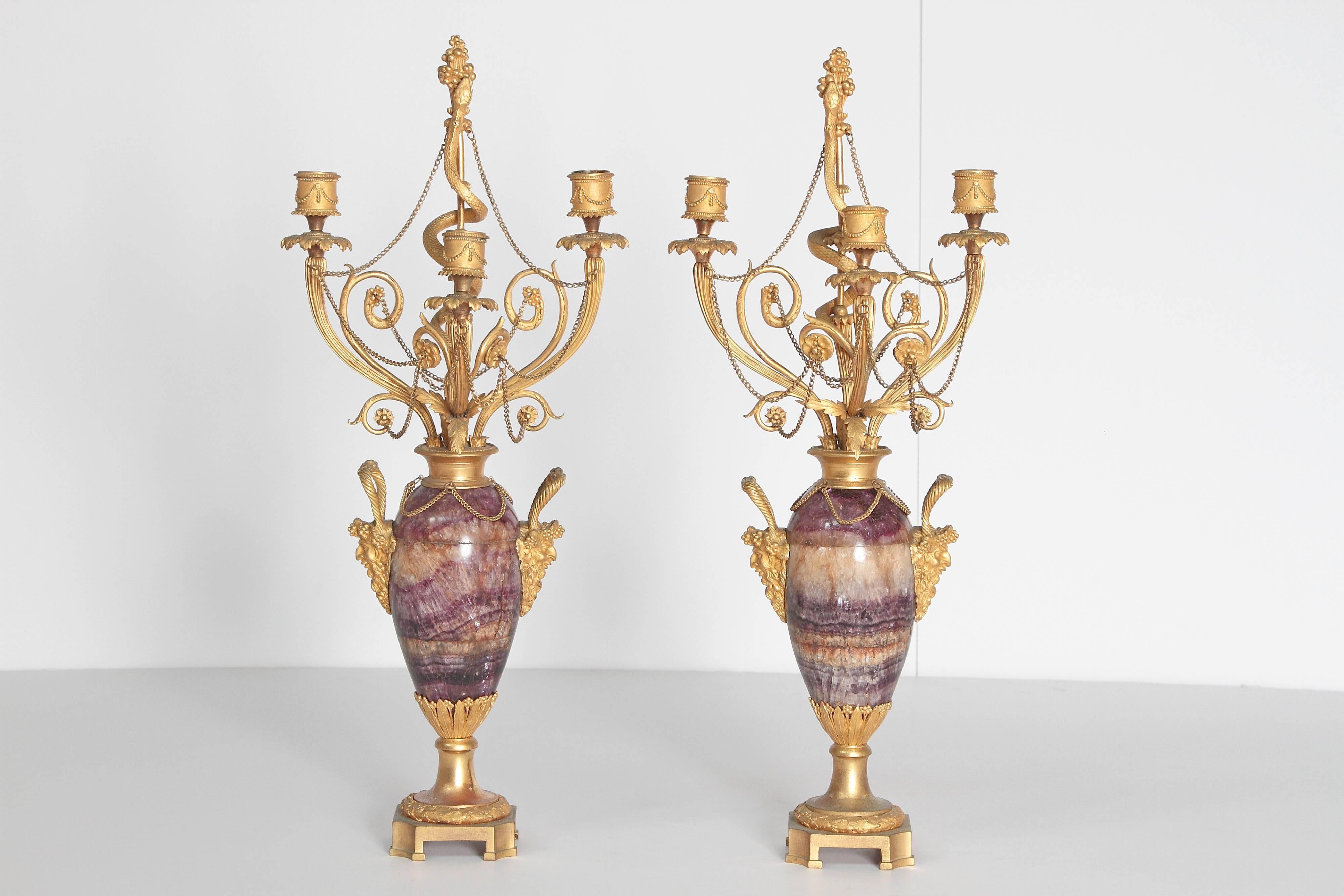 Neoclassical / Louis XVI-style gilt bronze mounted Blue John candelabra with Bacchus masks as handles each side, three (3) candleholders and center stem with serpent ascending, additional floral decorations and swags of gilt chain, 19th century