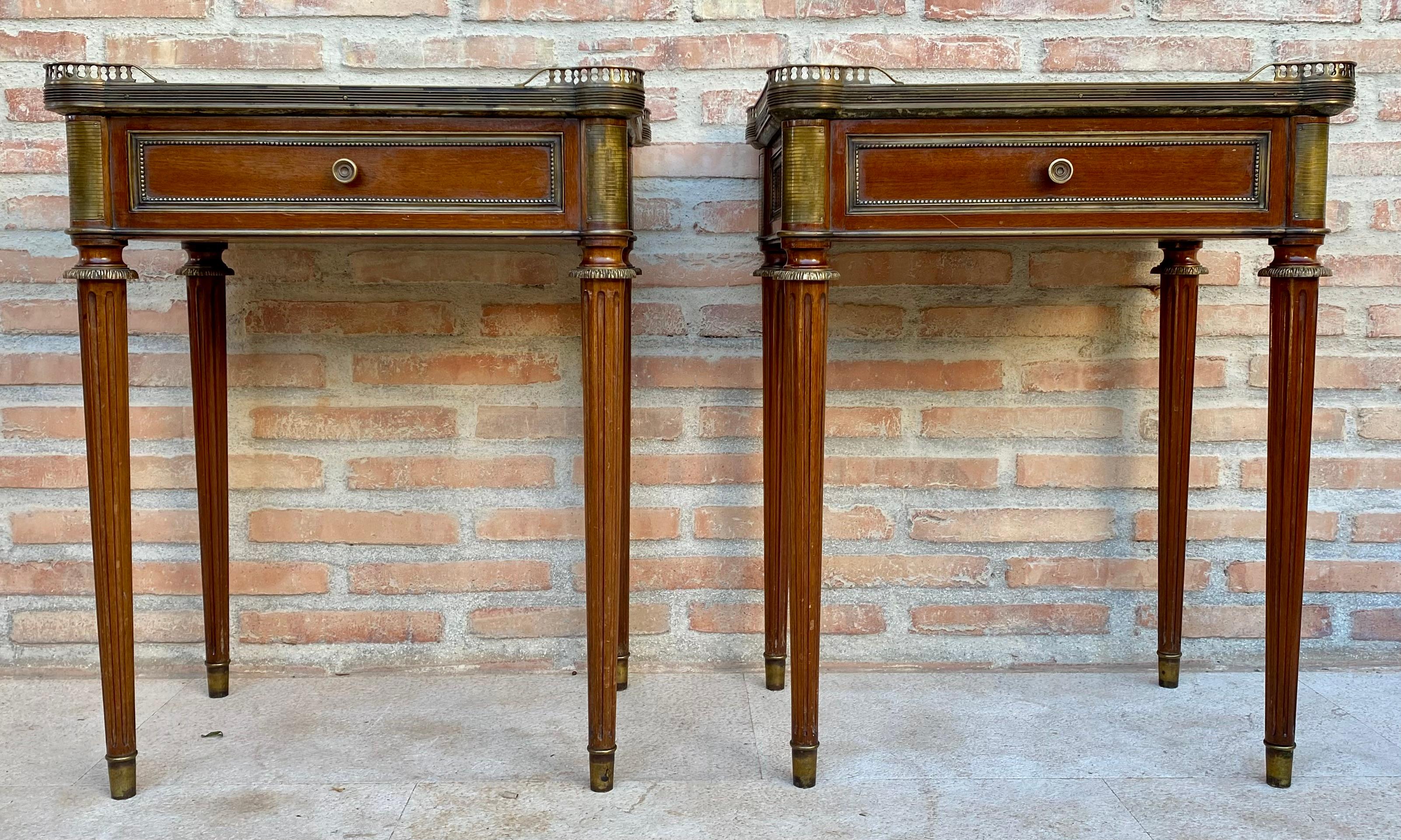 Insolite paire de tables de nuit ou d'appoint rectangulaires de style néoclassique du début du XXe siècle avec pieds cannelés et marbre vert et blanc.
Ils comportent un tiroir avec une poignée en bronze et le bas des pieds cannelés est décoré de