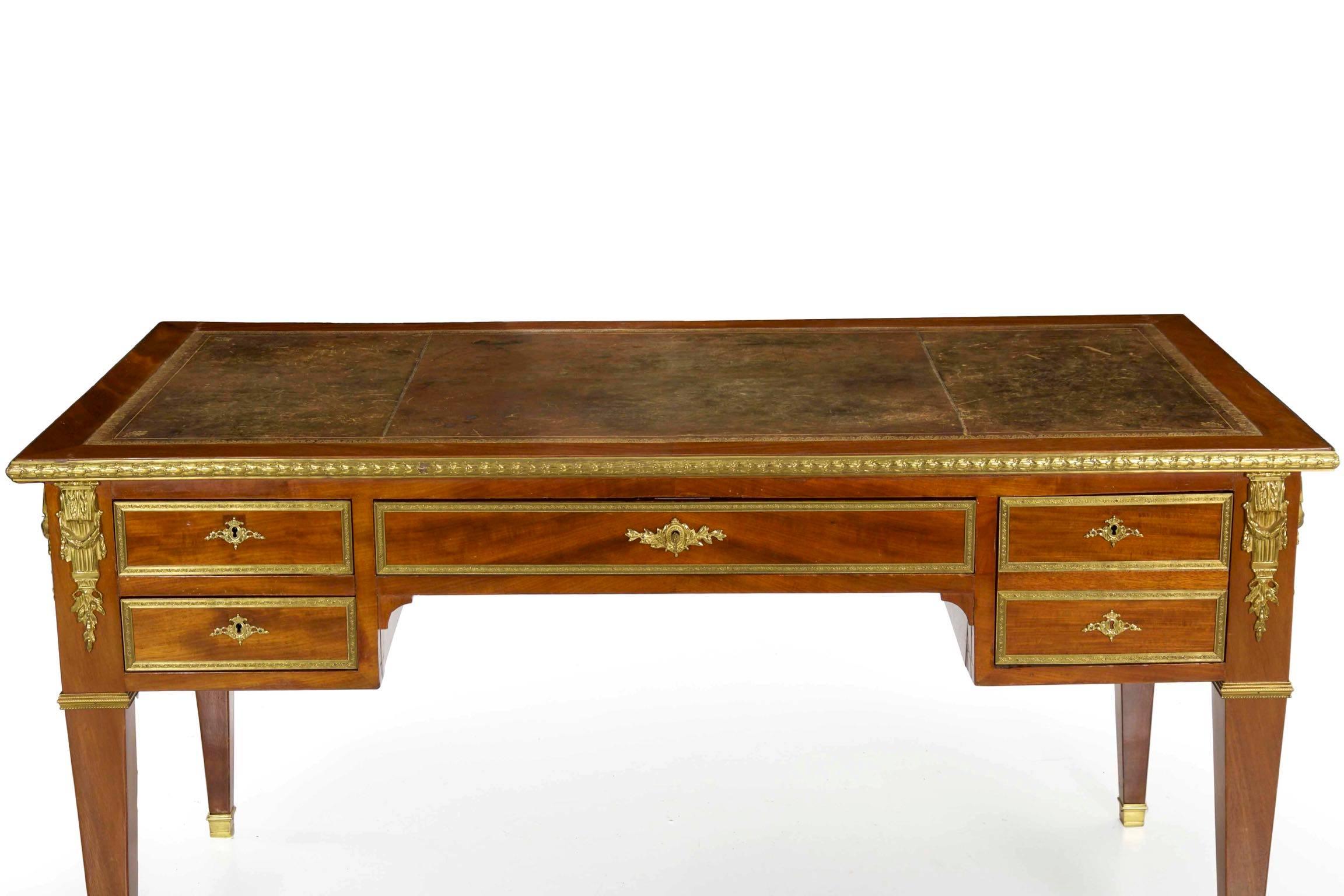 This inordinately fine bureau plat from the last quarter of the 19th century is a powerful and commanding form. The writing surface is so rich and attractive with a century of light wear and use stained into the cognac leather, a beautiful gilt