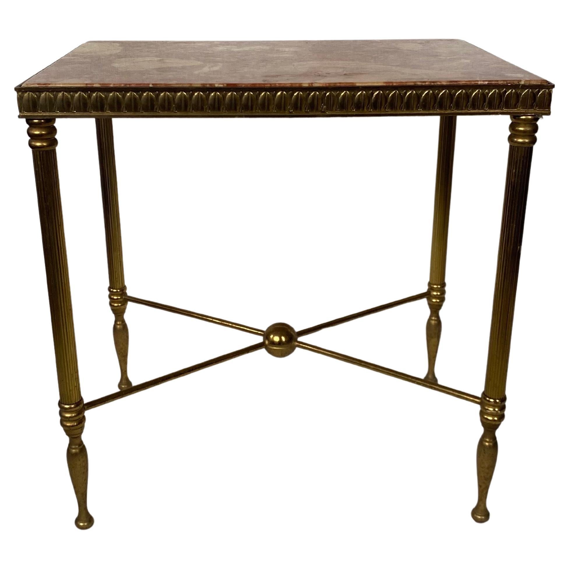Tavolino rettangolare in stile neoclassico, alla maniera della Maison Bagues.  La base in ottone patinato presenta un motivo a uovo e dardo in rilievo con una base a X e gambe scanalate.  È sormontato da un sorprendente piano in pietra di marmo