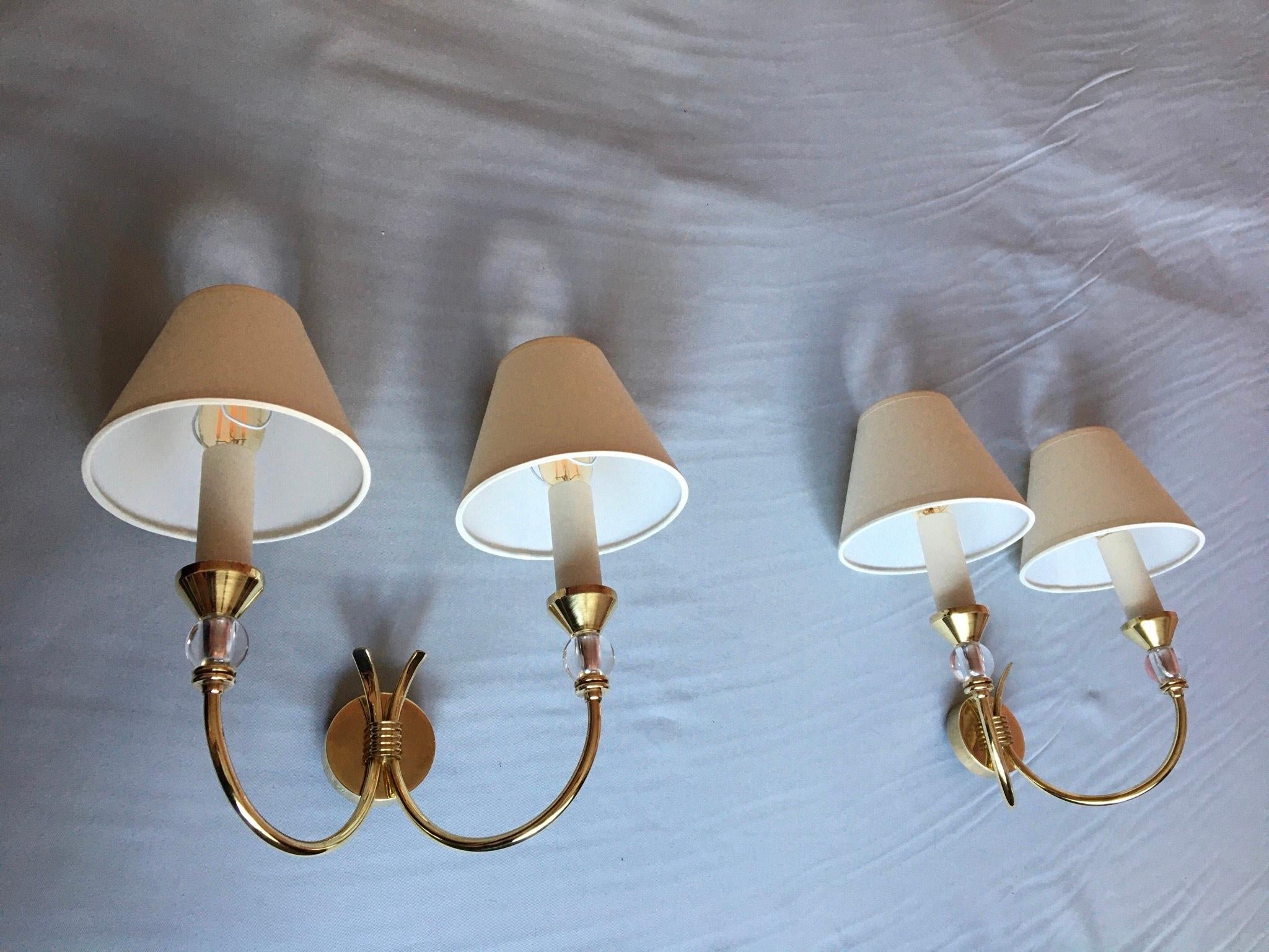 Very chic and stylish pair or French neoclassical double arm sconces of the 50’s in brass and lucite in the style of Maison Jansen.
The ivory cotton lamp shades are new and complimentary.
 ( maxi 40 watts )
Electrics parts have been renewed and