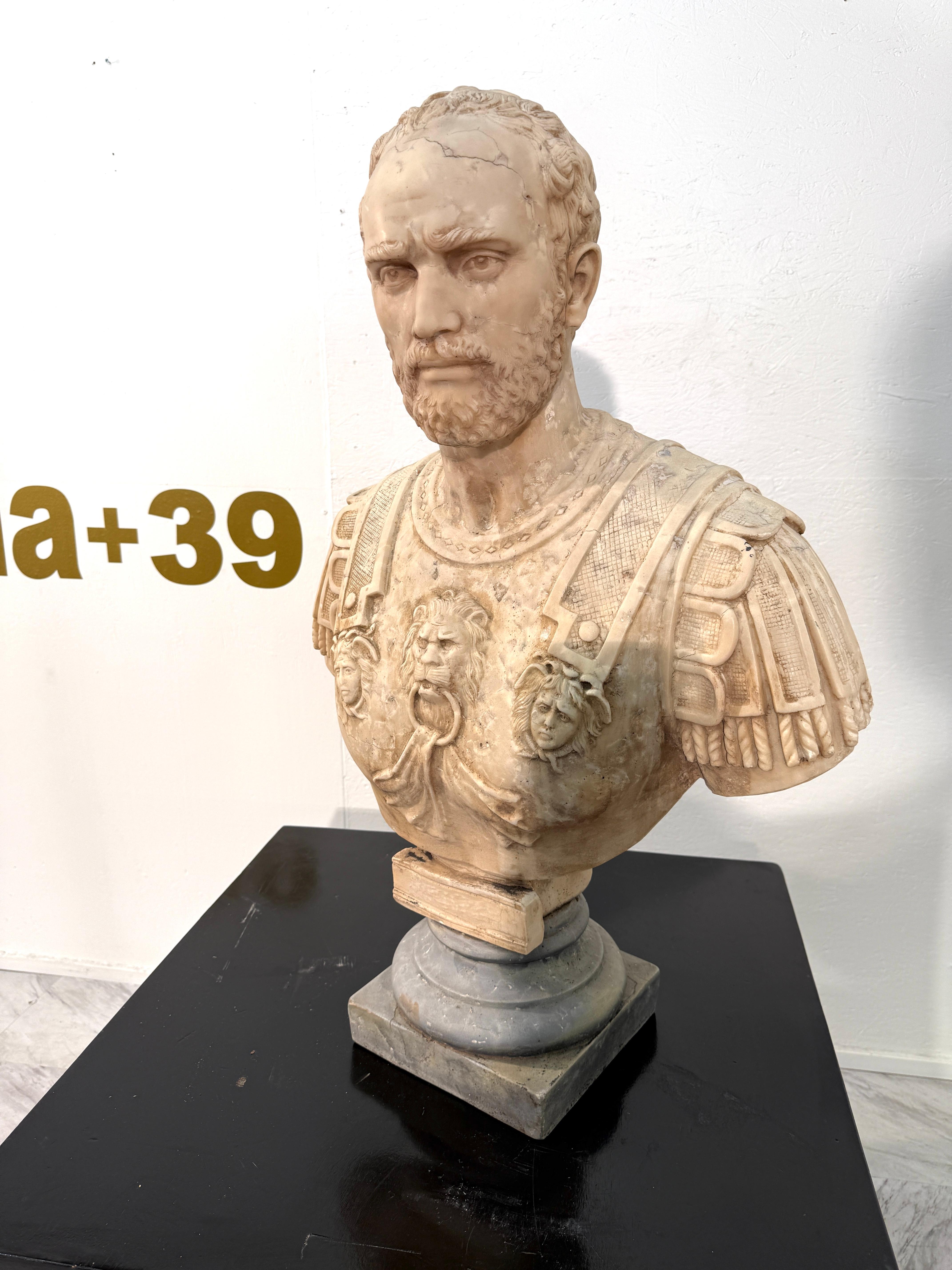 Buste en marbre néoclassique finement détaillé représentant un général romain en armure complète, orné de reliefs complexes de figures mythologiques et d'un motif de tête de lion imposant au centre de la cuirasse. Le visage sculpté exprime la