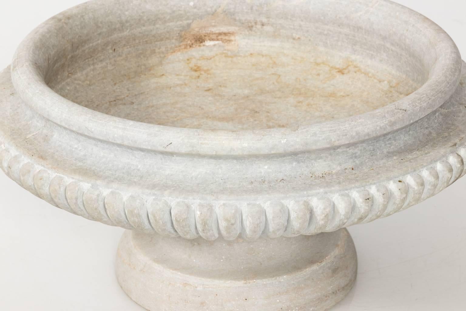 Large circular neoclassical marble urn with gadroon trim on a pedestal base, circa late 20th century.
 