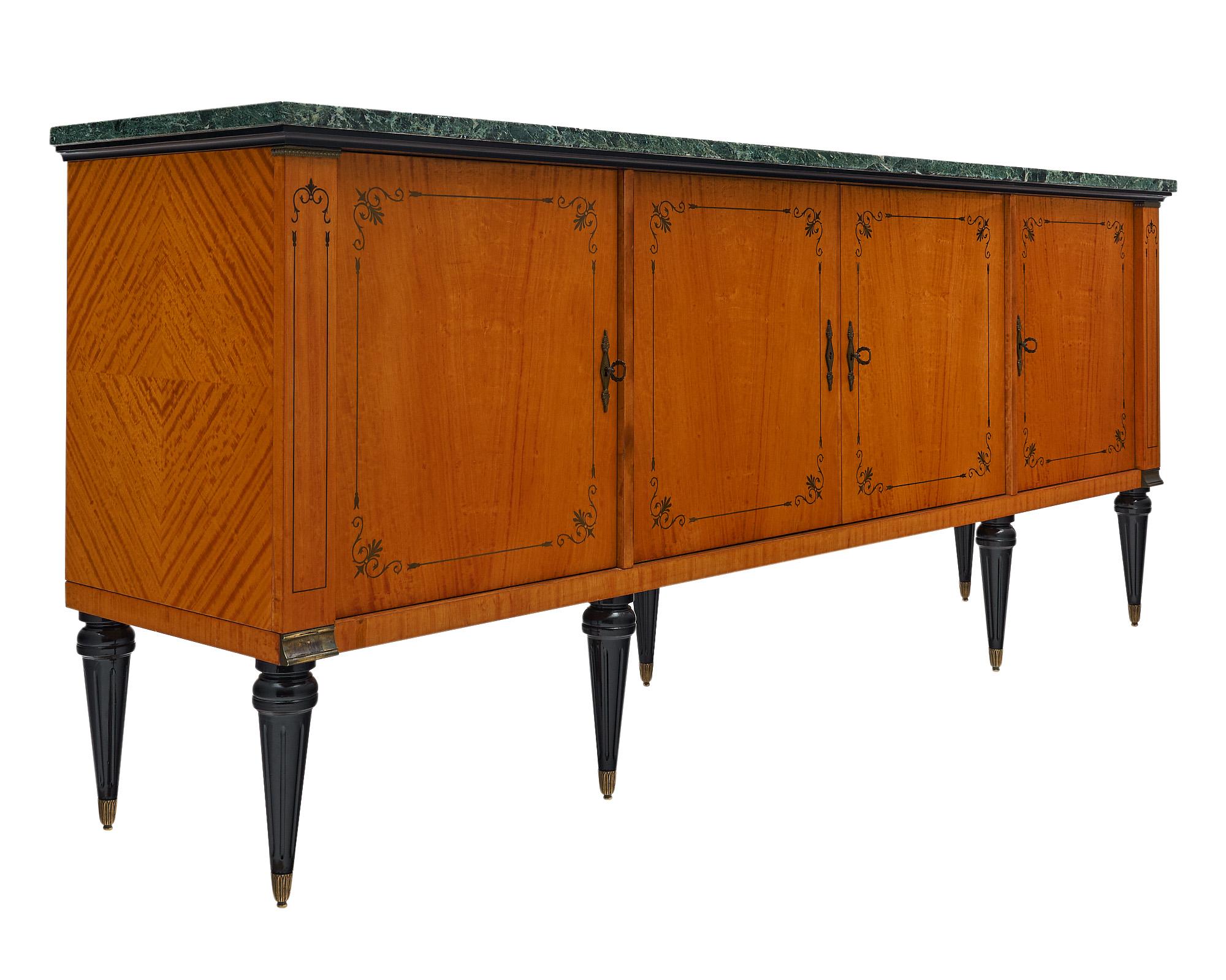 Buffet from France in the Modernist style with neoclassical lines. This piece boasts a striking flamed sycamore with a striking inlay on the four doors inlayed wit ebony. This expertly crafted enfilade is supported by ebonized, tapered legs. The