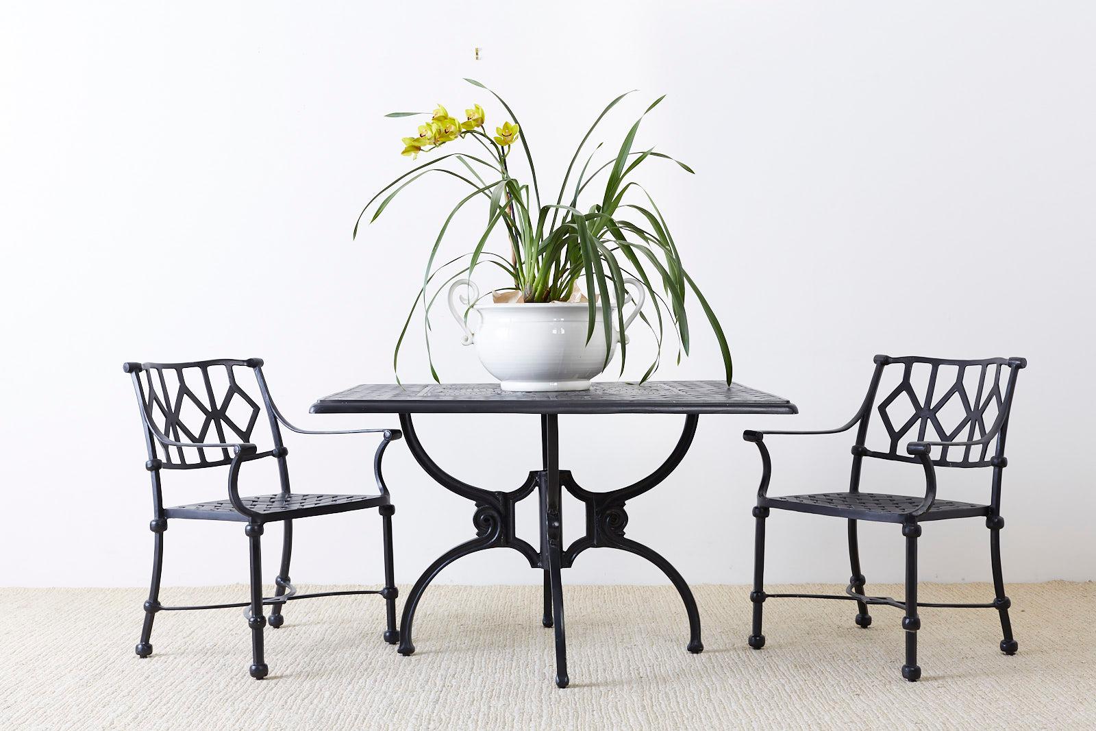 Impressive patio and garden dining table made in the manner and style of Molla. Constructed from ebonized cast aluminium in the neoclassical taste. Features a woven design top with decorative floral foliate motif in the center. Supported by thick