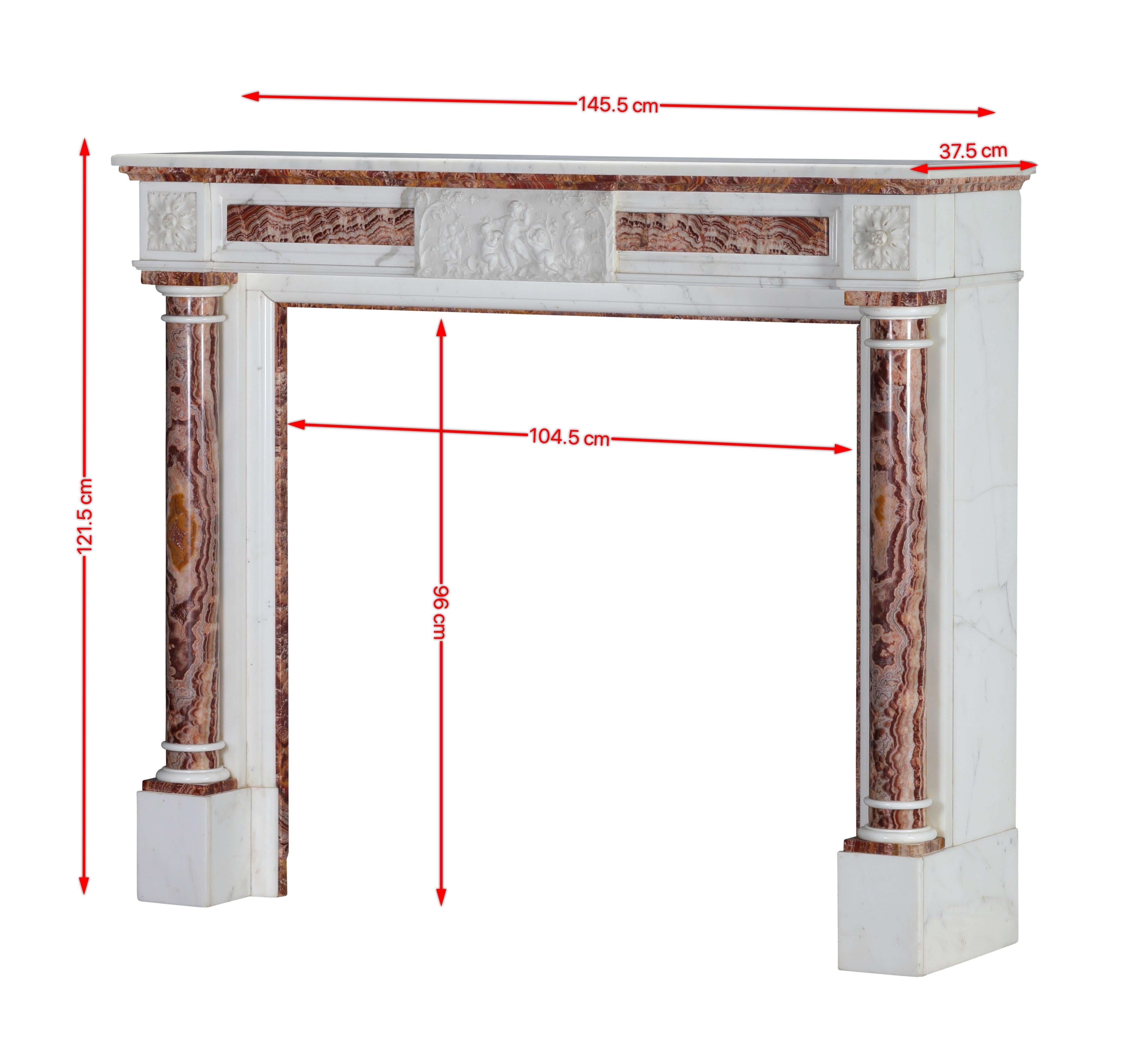 Cheminée néoclassique exclusive avec colonnes.

Le design présente des sculptures ornées mais équilibrées, des motifs classiques avec des chérubins qui jouent, et des finitions luxueuses en marbre et en onyx. Il fusionne l'élégance historique avec
