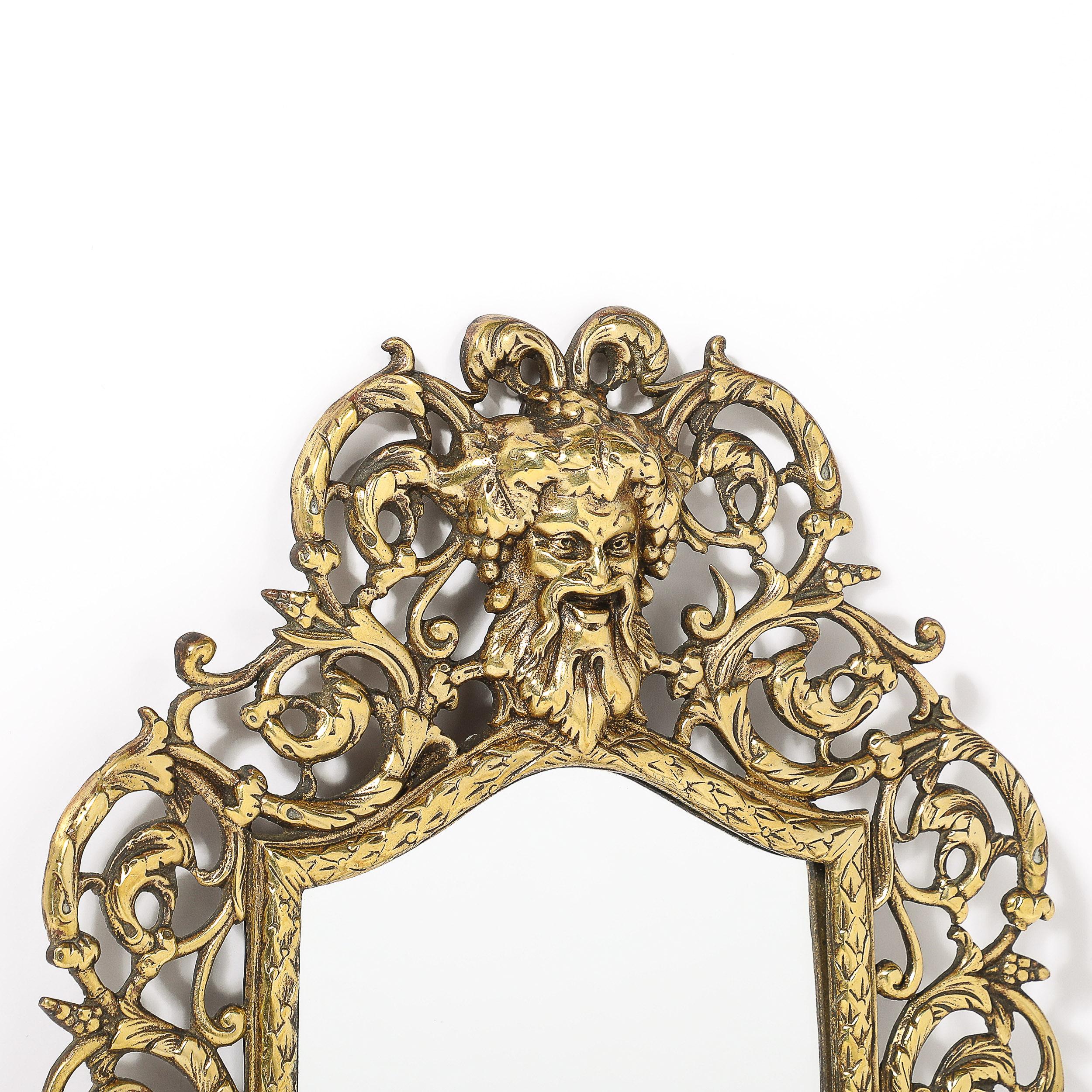 This uniquely exquisite Neoclassical Ornate Brass Framed Mirror W/Sculptural Baccus & Vine Motif originates from the United States, Circa 1880. Features an arch form central pane of mirror, circumscribed by a chained series of nested wheat. The top