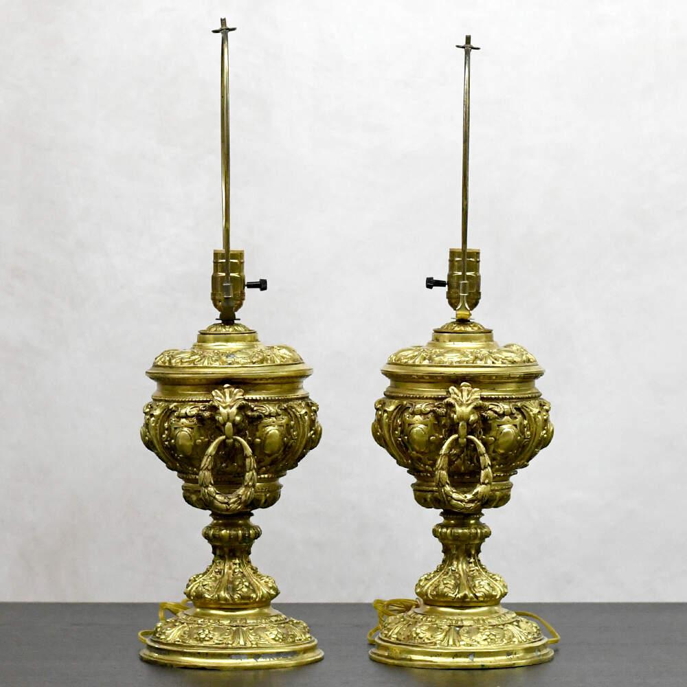 Characterized by a fascination with symmetry, proportion, and classical ornamentation, these Neoclassical Ornate Ram Head Gold Table Lamps emulate the grandeur and refinement of antiquity while infusing it with a sense of modern sensibility. Across