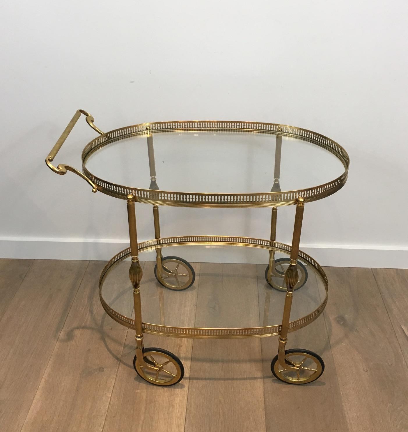 This neoclassical oval bar cart is made of brass with 2 glass shelves. This is a very fine work and this drinks trolley can be attributed to Maison Jansen, French, circa 1940.