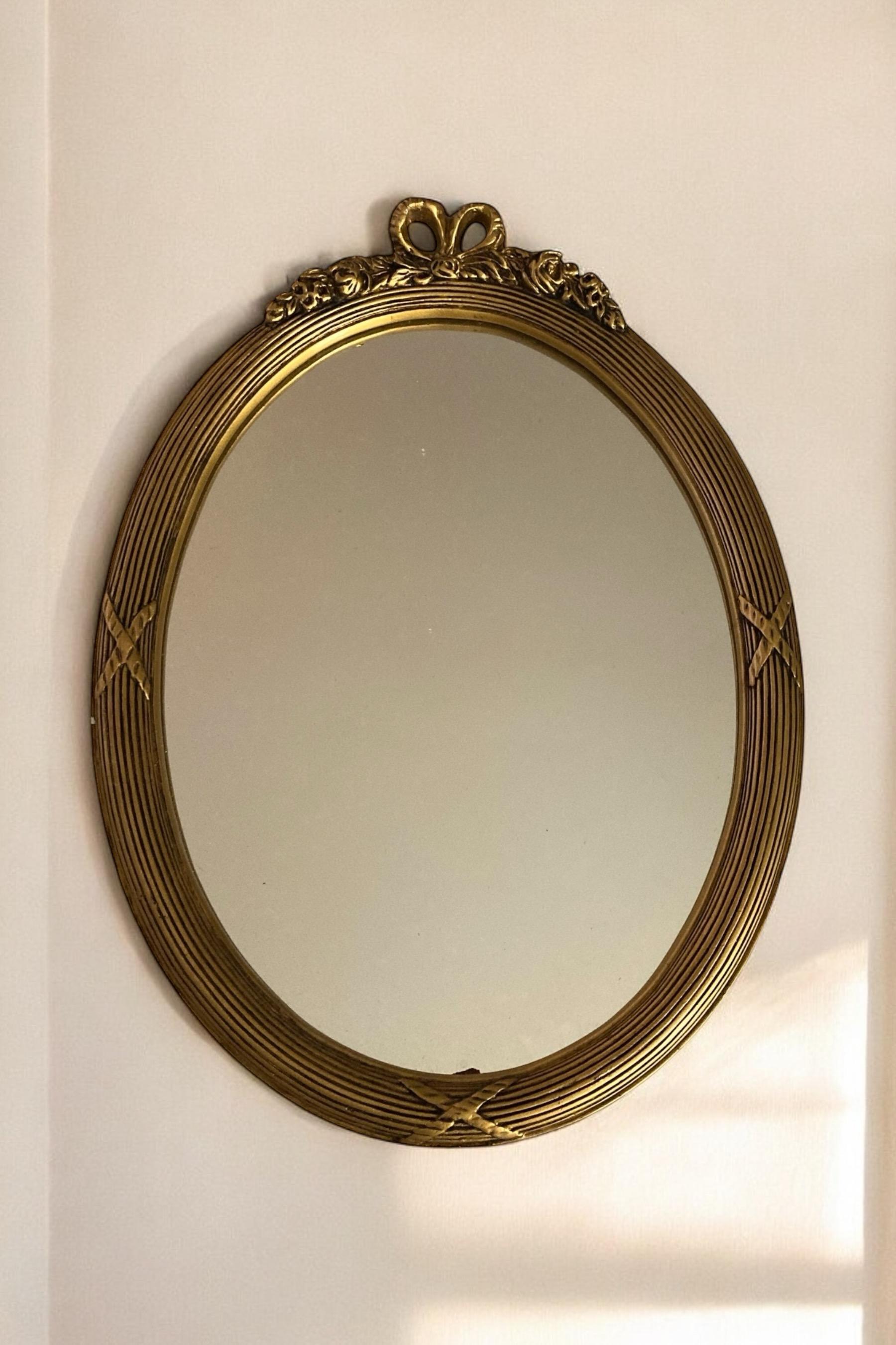 Espejo de pared neoclásico oval dorado siglo XX en venta