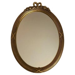 Espejo de pared neoclásico oval dorado