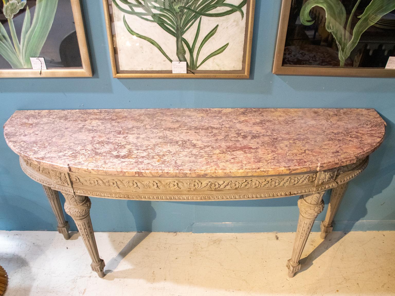 Neoclassical grey painted console with marble top, circa 1920s. The piece is detailed neoclassical motifs such as carved floral guilloche trim on the skirt and laurel wreaths on the turned legs. Please note of wear consistent with age including