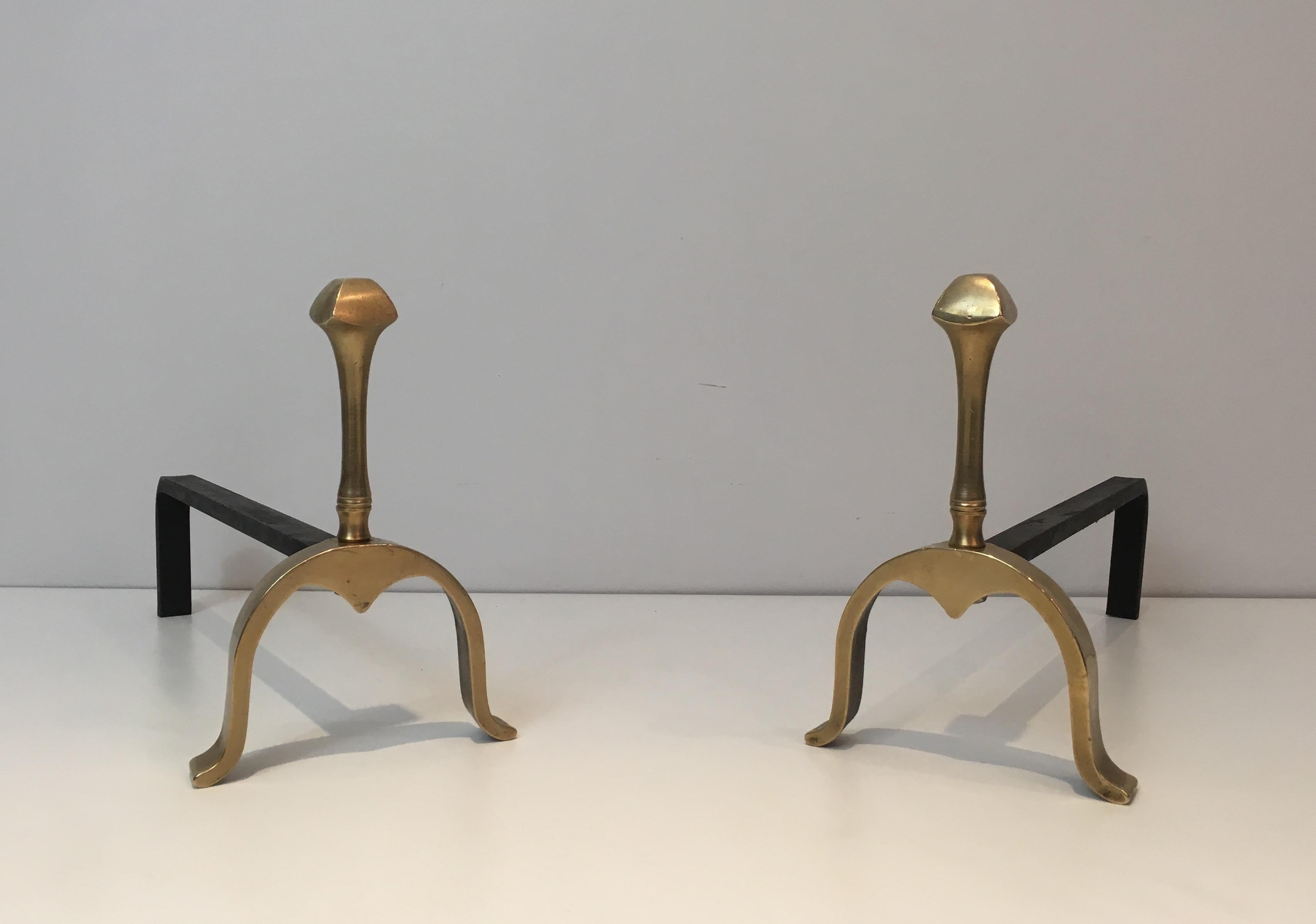This neoclassical pair of andirons is made of brass and iron. This is a French work, circa 1970.