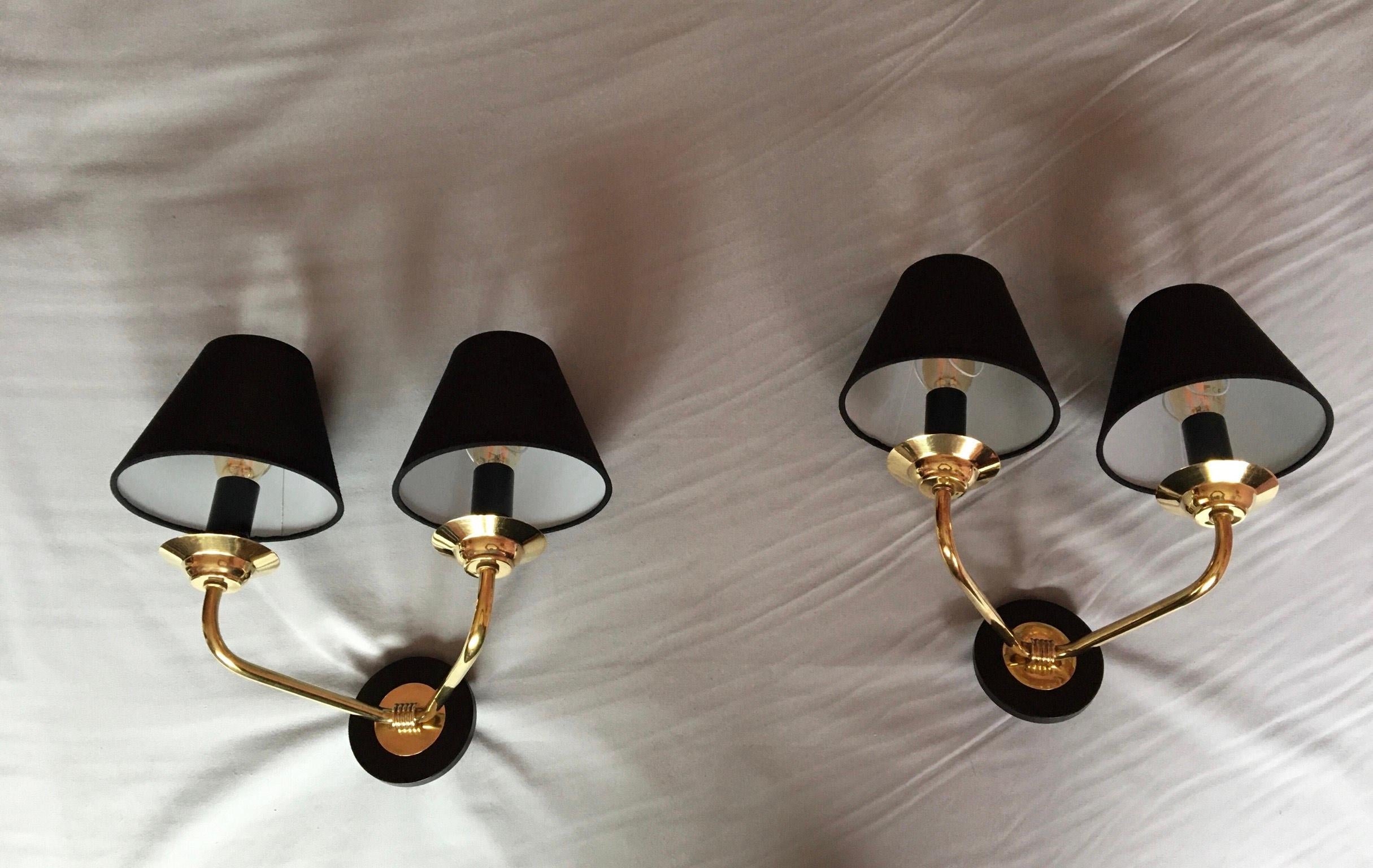 Very stylish pair of French Neoclassical style double sconces of the 50's in brass and black lacquered metal in the style of Maison Jansen.
The pair is in very good condition, electrical parts have been renewed and fit the US standard. ( 150 watts