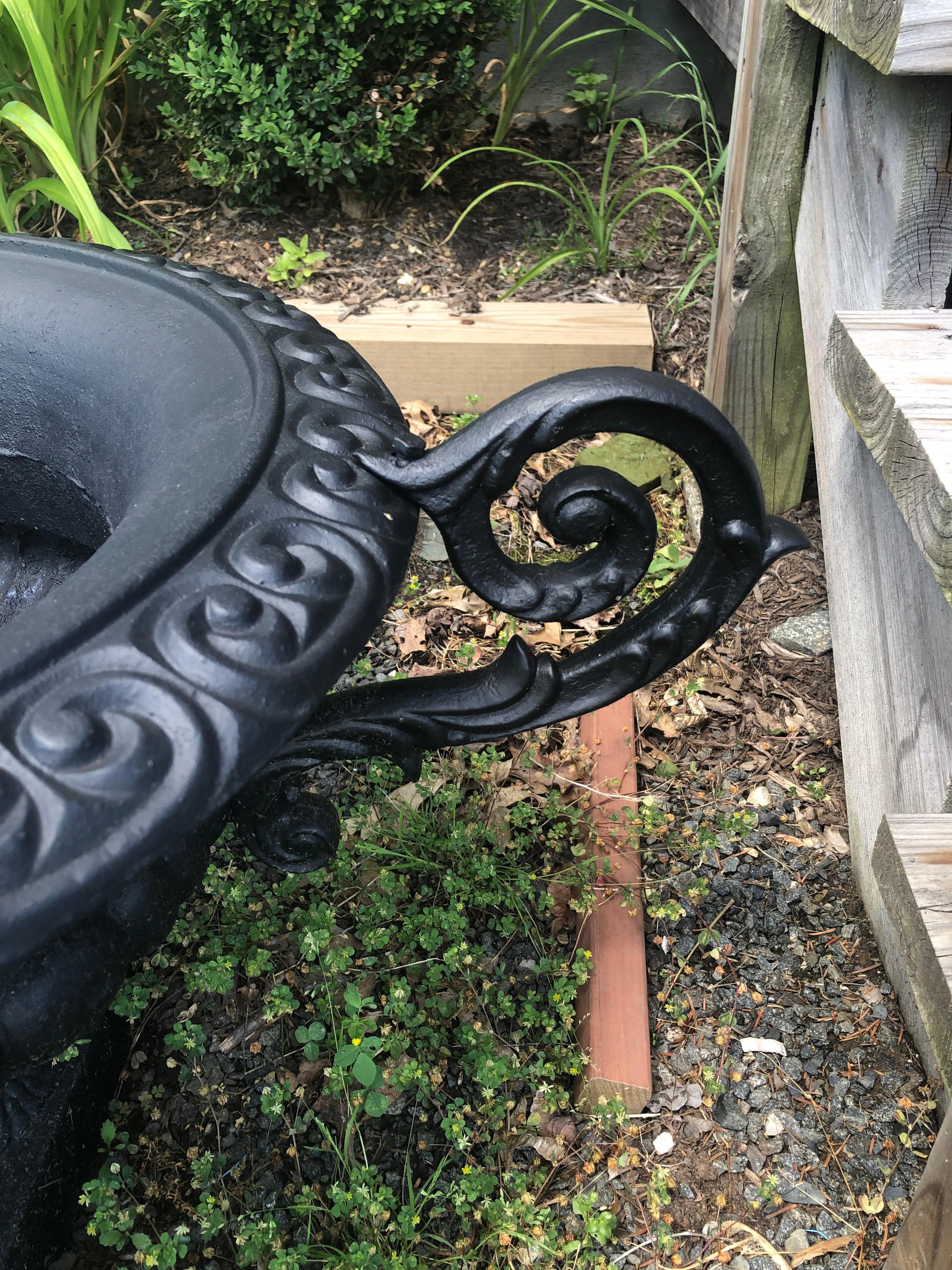 Beautiful pair of vintage cast iron planters having elaborate handles and neoclassical form and decoration.  Just painted black.
35 w handle to handle
24 w outer edge of bowl
internal width is 14
(Dragert).