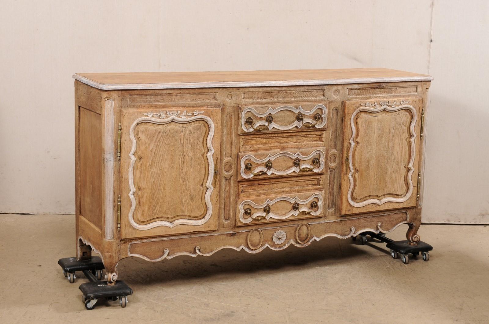 A French neoclassical period carved oak buffet cabinet from the early 19th century. This antique console cabinet from France has nicely appointed details and features a rectangular-shaped top with softly rounded front corners, over a case which