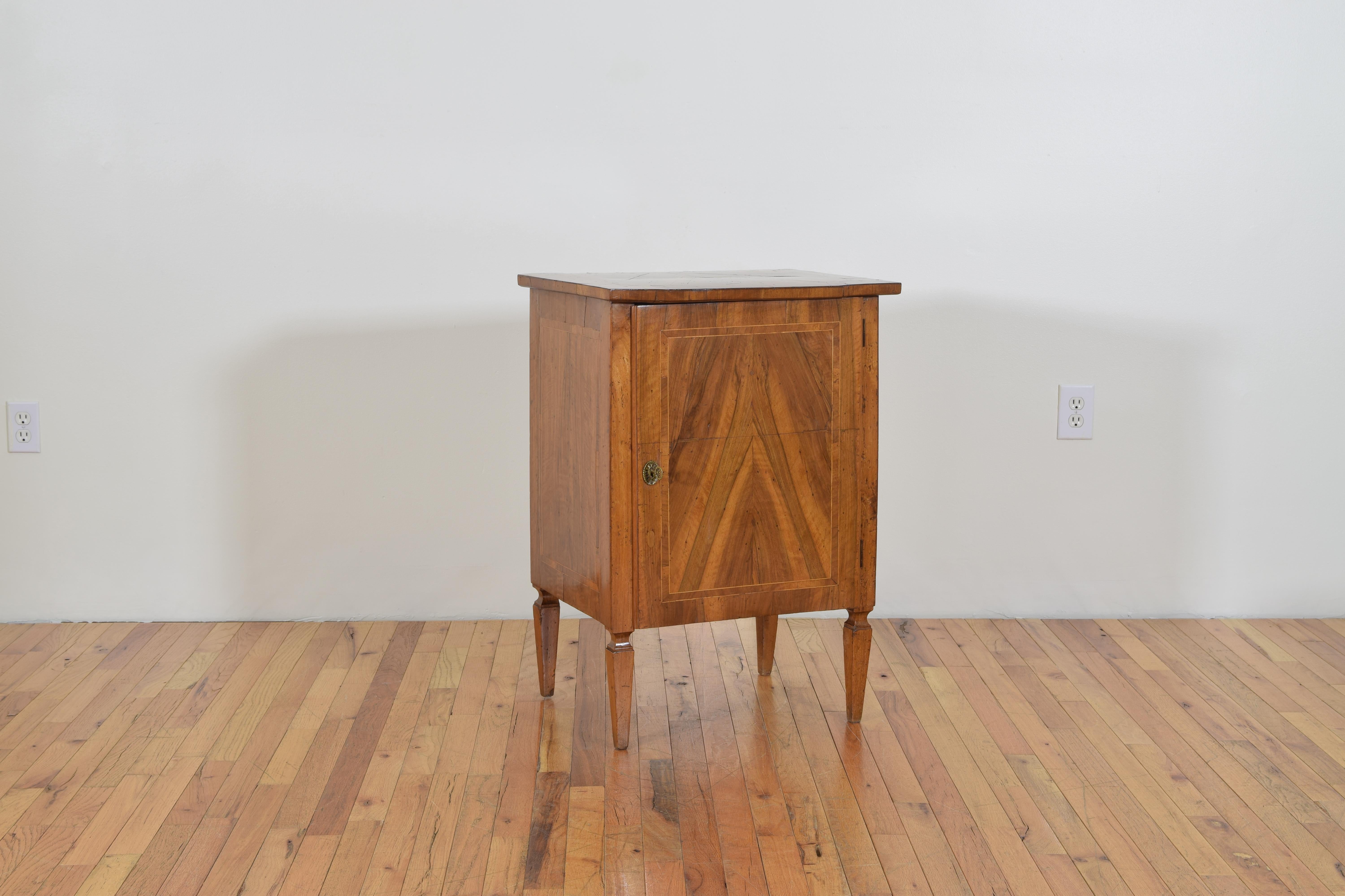 Italian neoclassical cabinet having a rectangular top above a conforming case and inlaid one-door, raised on square tapering legs.