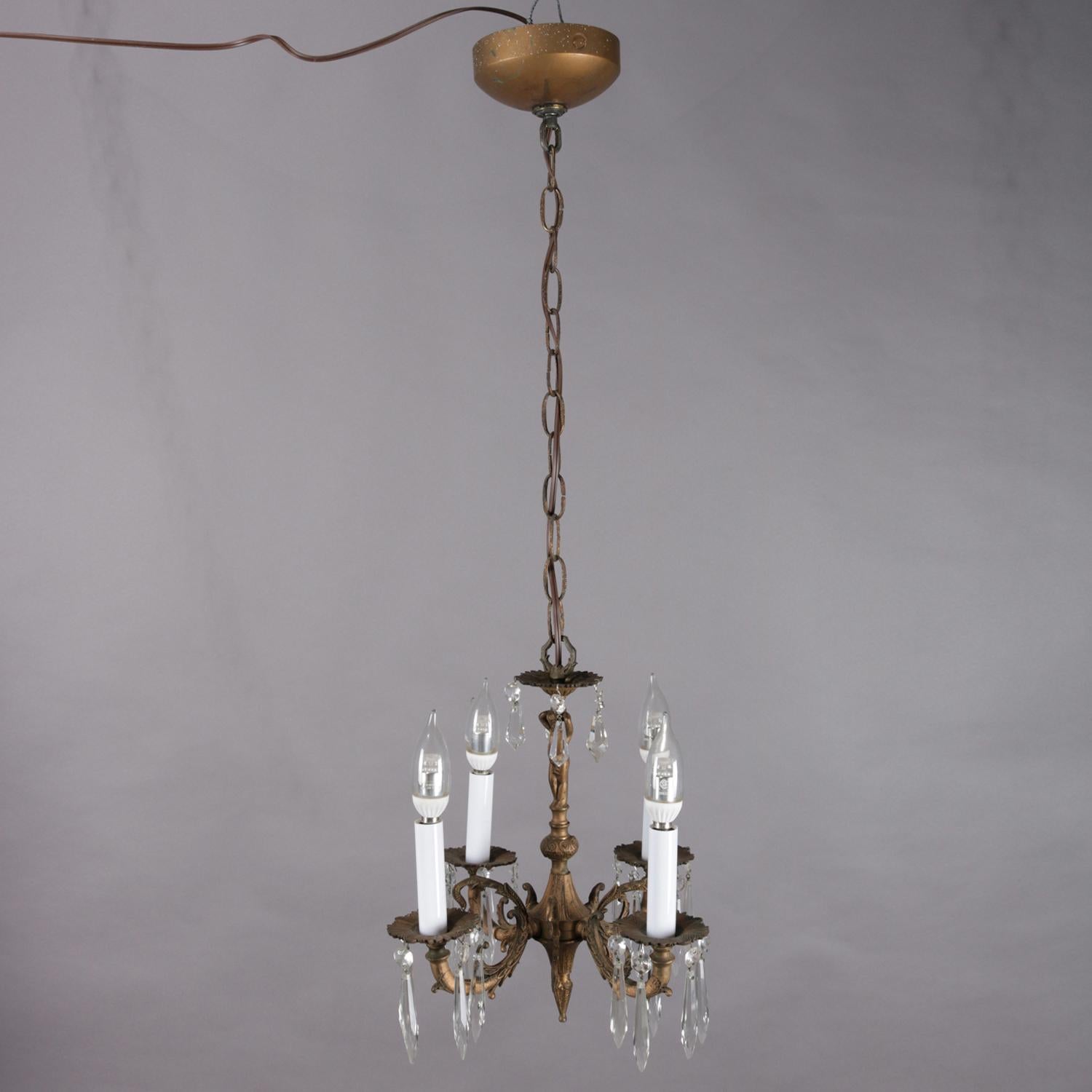 A neoclassical figural petite branch chandelier features bronzed metal frame with cherub column having four foliate decorated c-scroll arms terminating in candle lights, cut crystal hanging prisms throughout, additional prism receptors (designer