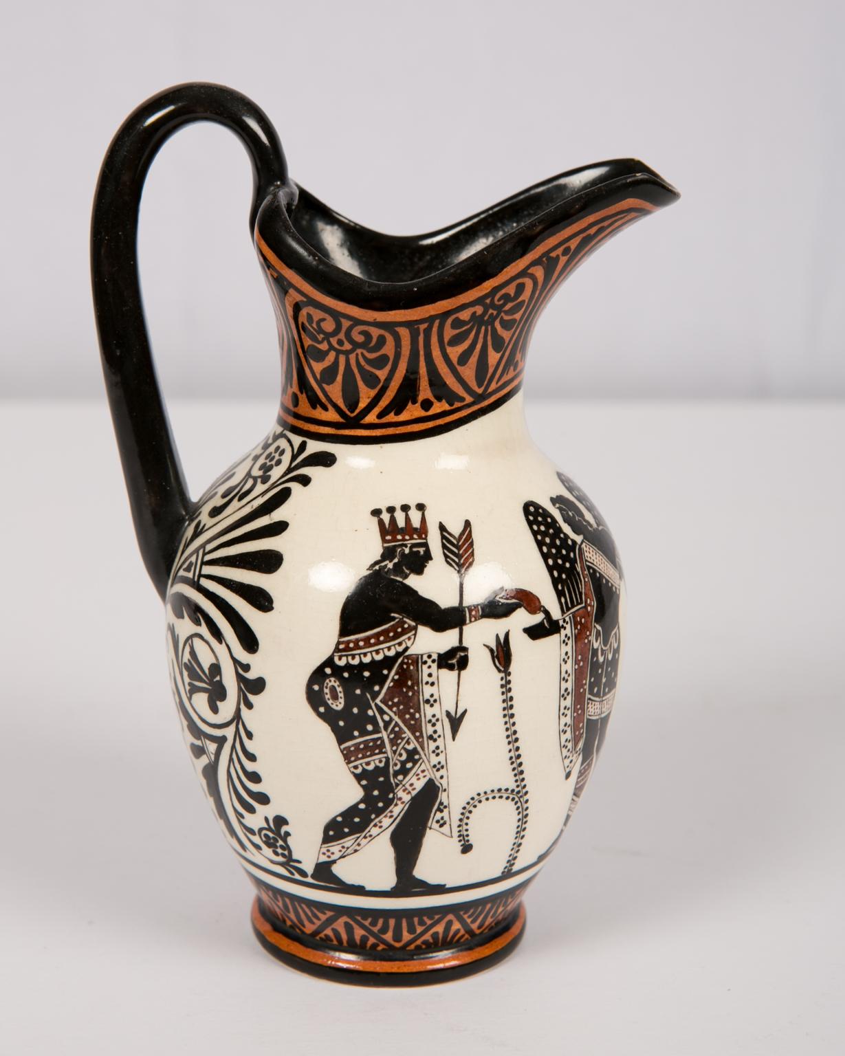 This small Etruscan Revival pitcher (5.75 inches tall) is painted orange, black, and ochre. 
It was made circa 1840 by Giustiniani, the Italian ceramicist factory. 
The pitcher is marked on the underside with Giustiniani's impressed 