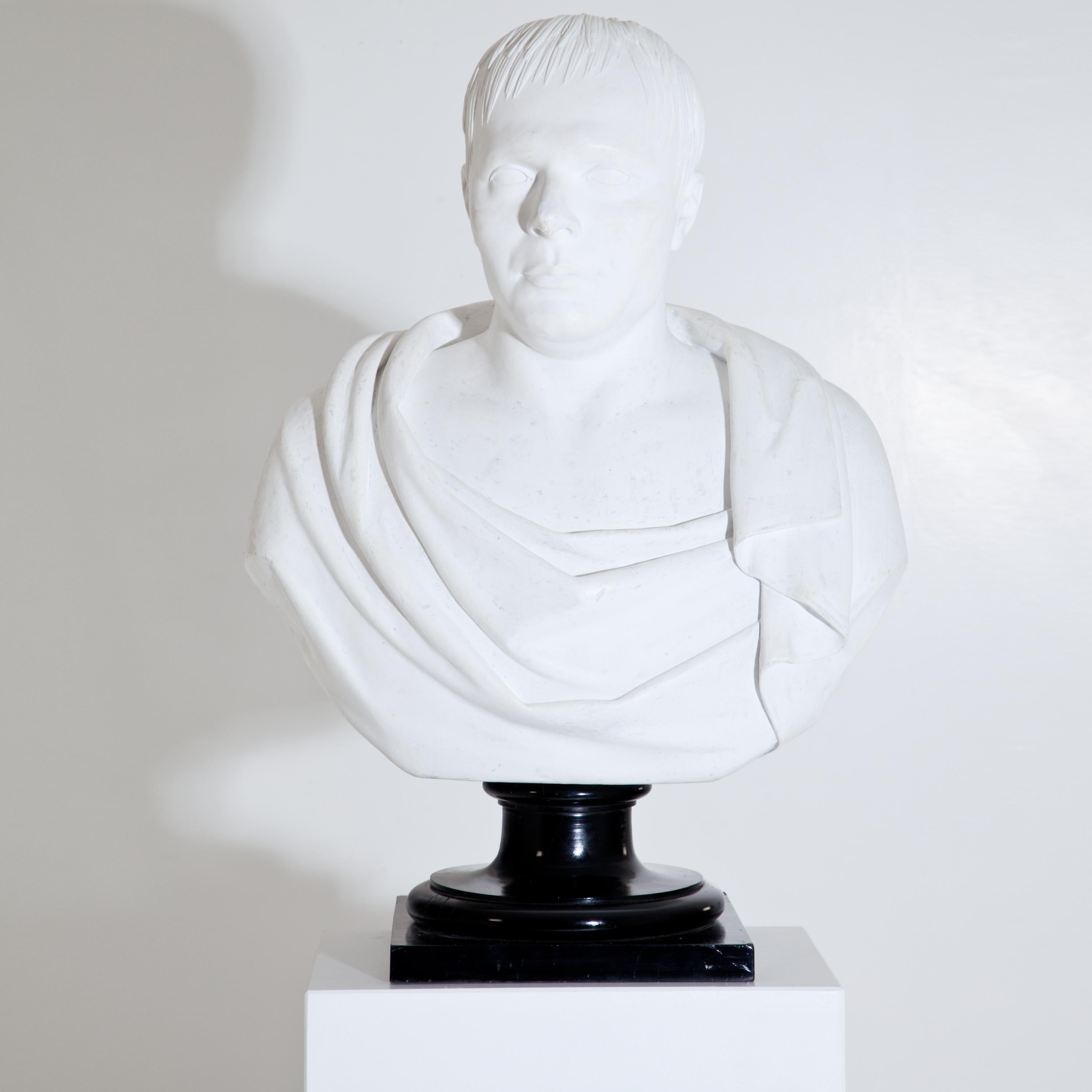 Large portrait bust of a middle-aged man in antique garb. The plaster bust is signed A. Frederich and dated 1843 on the underside and stands on an ebonised wooden column base. The bust was expertly cleaned and minimally restored. (Dimensions plinth: