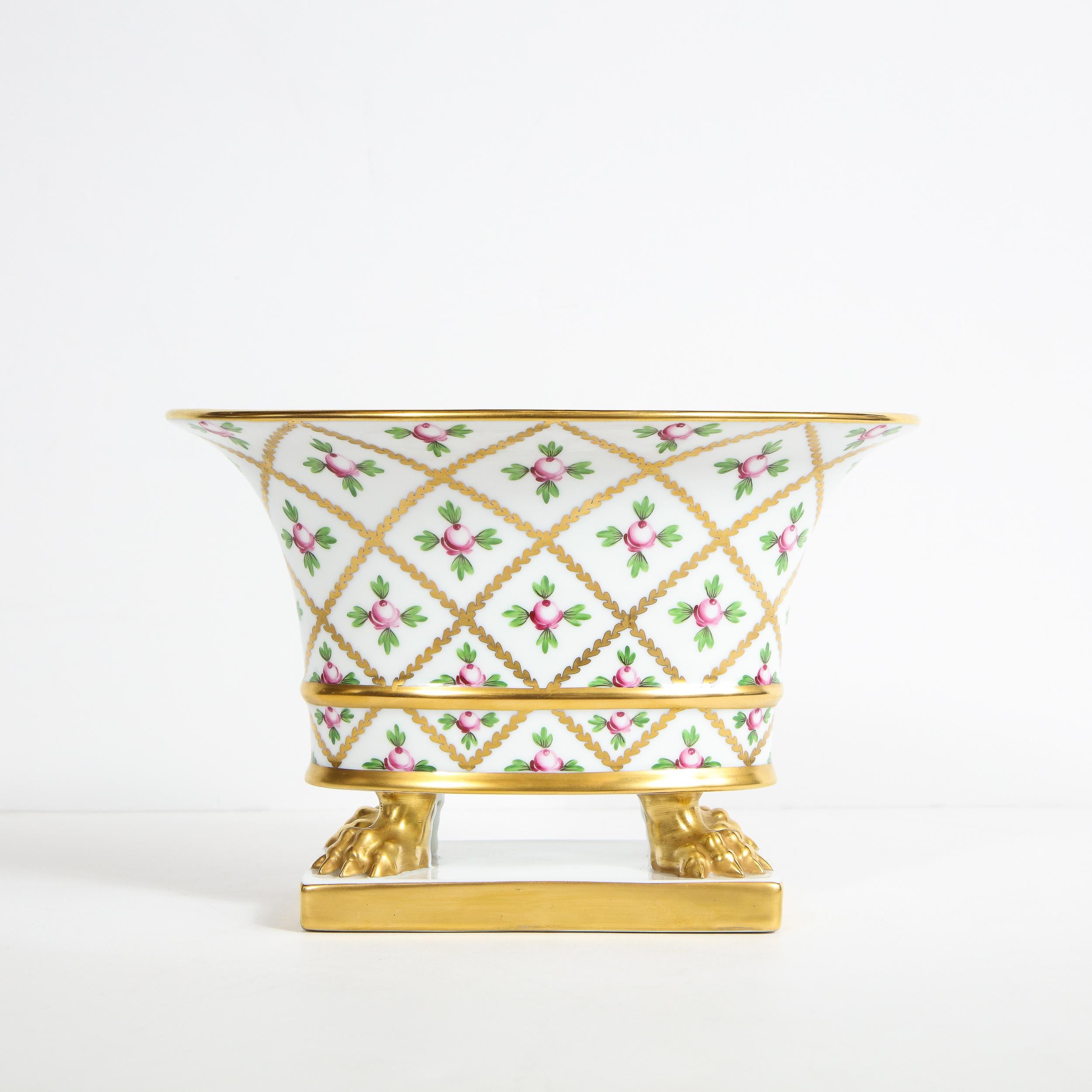 This elegant neoclassical cachepot was realized by the esteemed maker Herend of Hungary. It features stylized 24kt yellow gold hand painted clawfeet on a white porcelain based circumscribed in yellow gold. The piece offers a elliptic form that