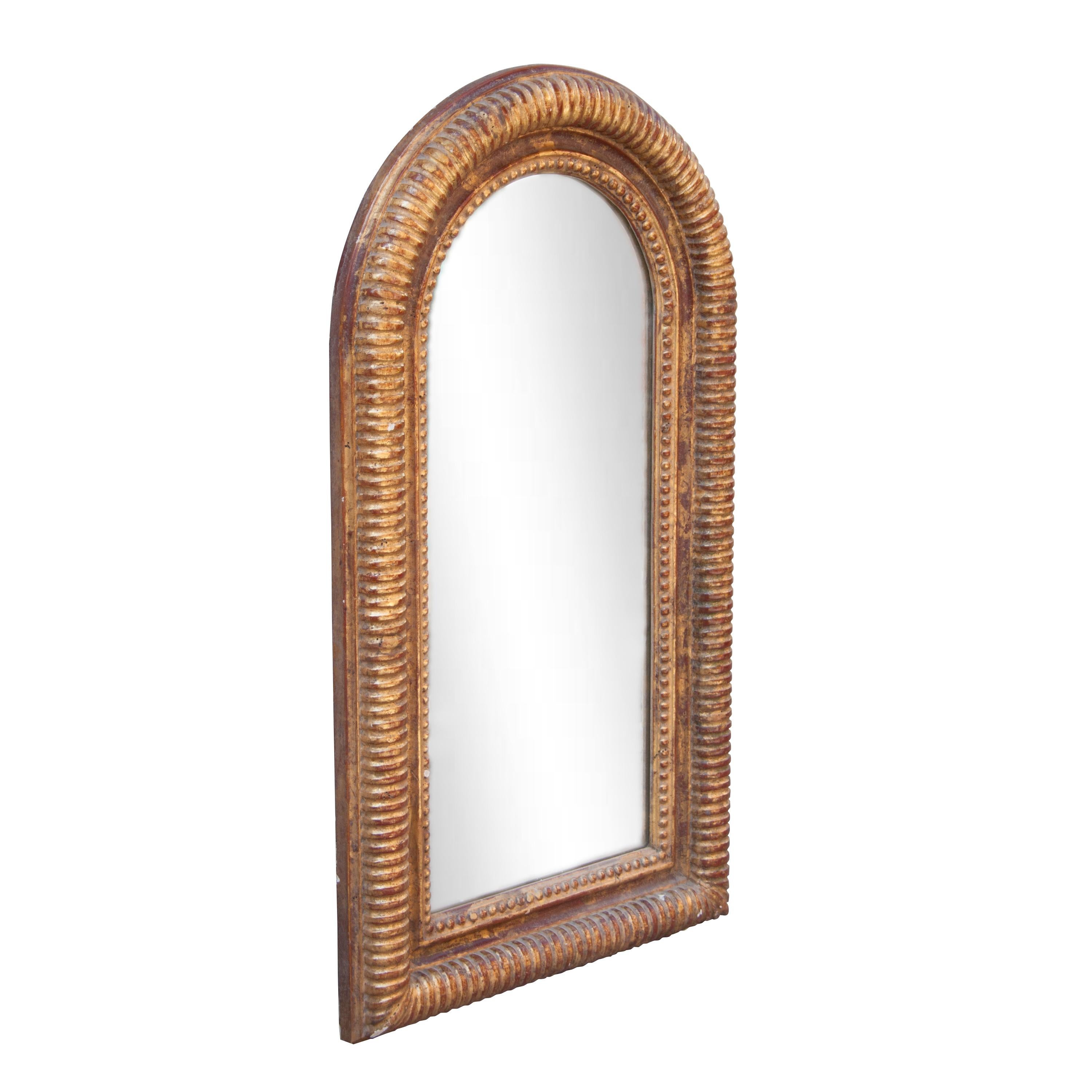 Neoclassical Regency style handcrafted mirror. Arch hand carved wooden structure with gold foiled finish, Spain, 1970.
