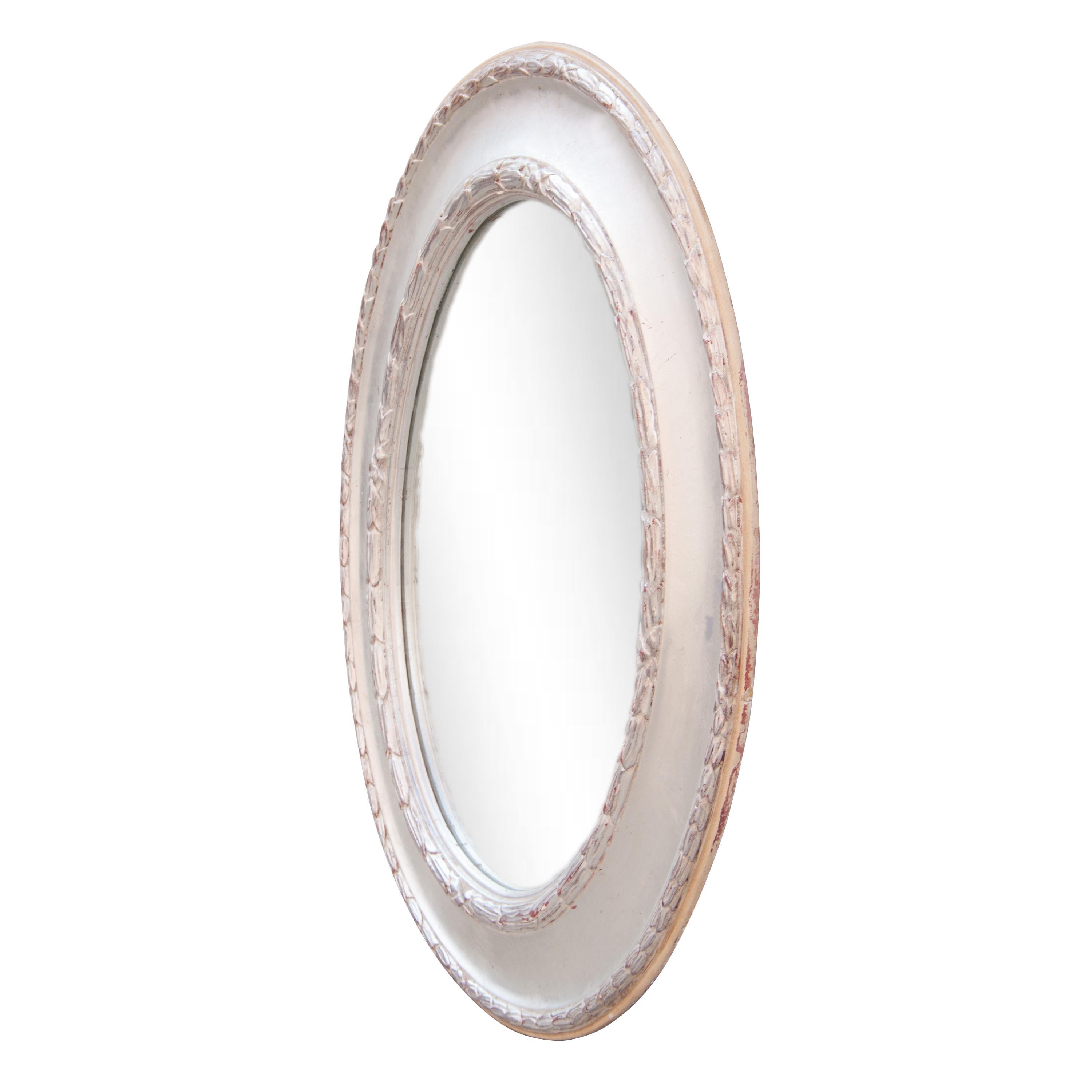 Neoclassical Regency style handcrafted mirror. Oval hand carved wooden structure with silver foiled finish, Spain, 1970.