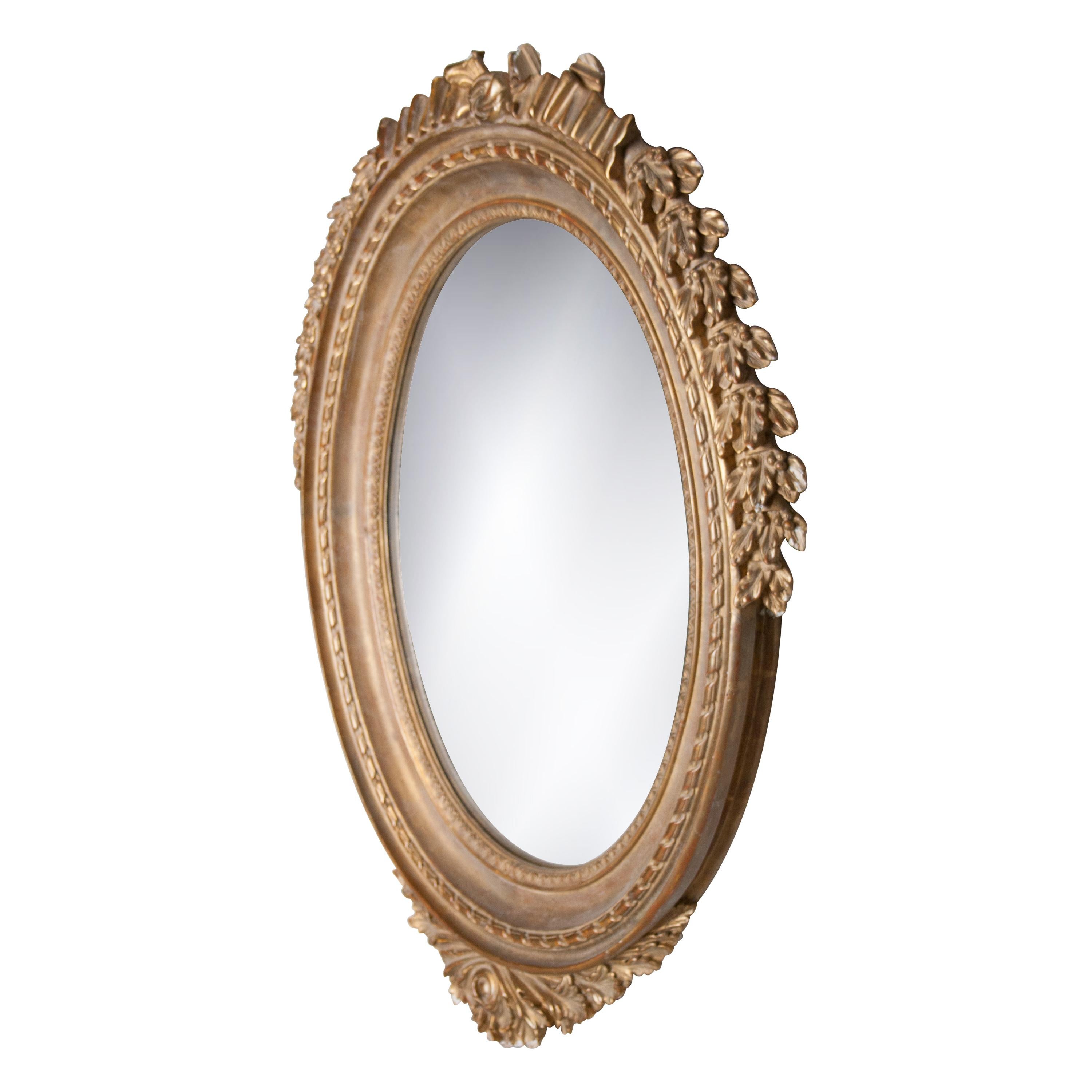 Specchio artigianale in stile Regency neoclassico. Struttura rotonda in legno intagliato a mano con foglia d'acanto e finitura in lamina d'oro. Spagna, 1970.