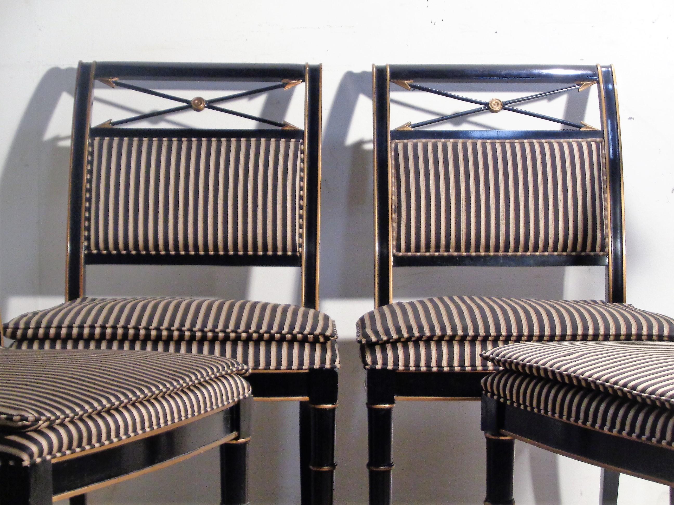 Ensemble de quatre chaises d'appoint / chaises de salle à manger de style néoclassique Regency. Assise et dossier tapissés de rayures, pieds tournés en faux bambou, flèches croisées dorées sur le haut du dossier. Finition d'usine d'origine laquée