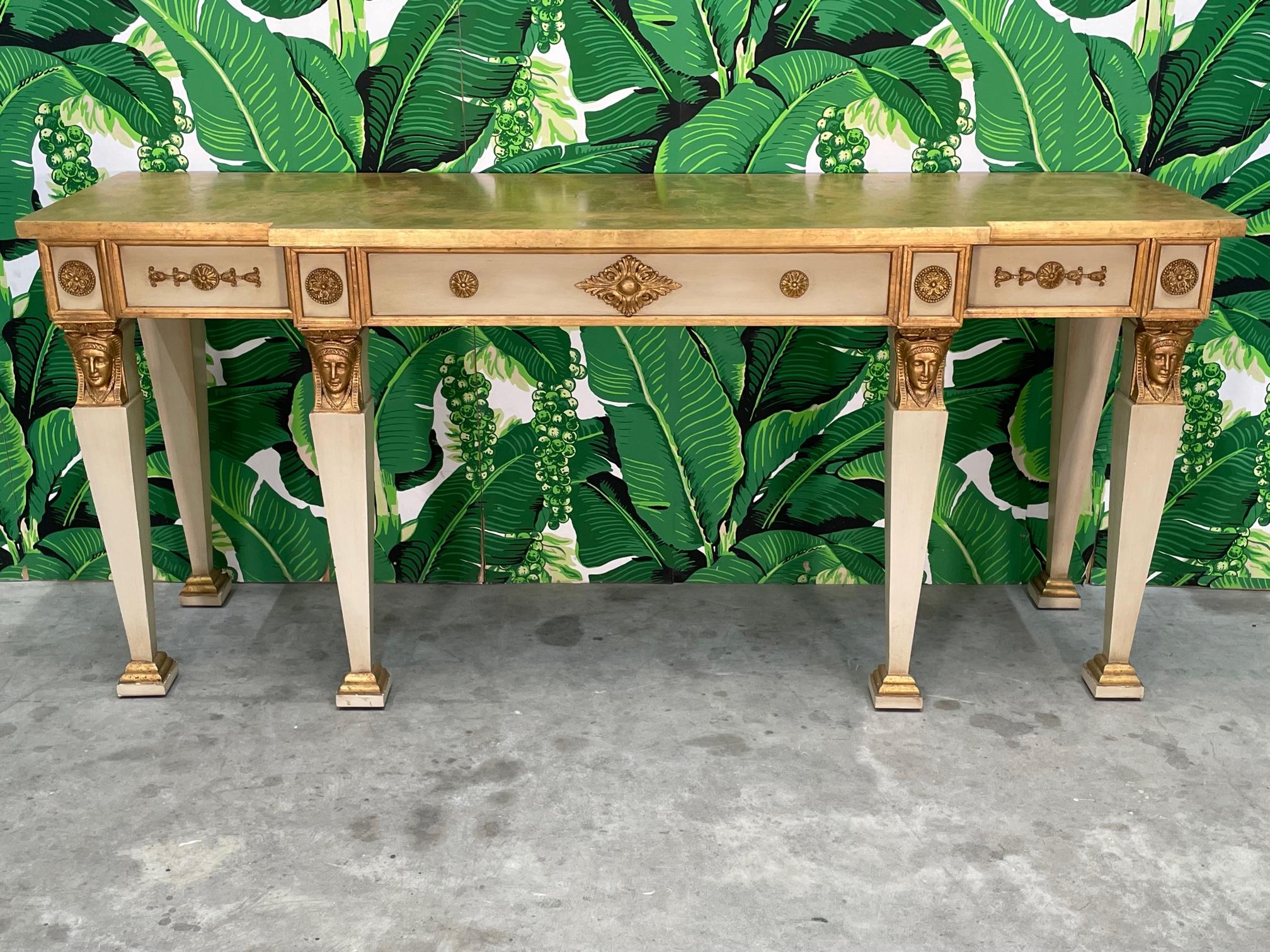 Neoclassical style console features a breakfront design highlighted by carved faces and ornate appliquéd detailing. Good condition with imperfections consistent with age, see photos for condition details. 
For a shipping quote to your exact zip