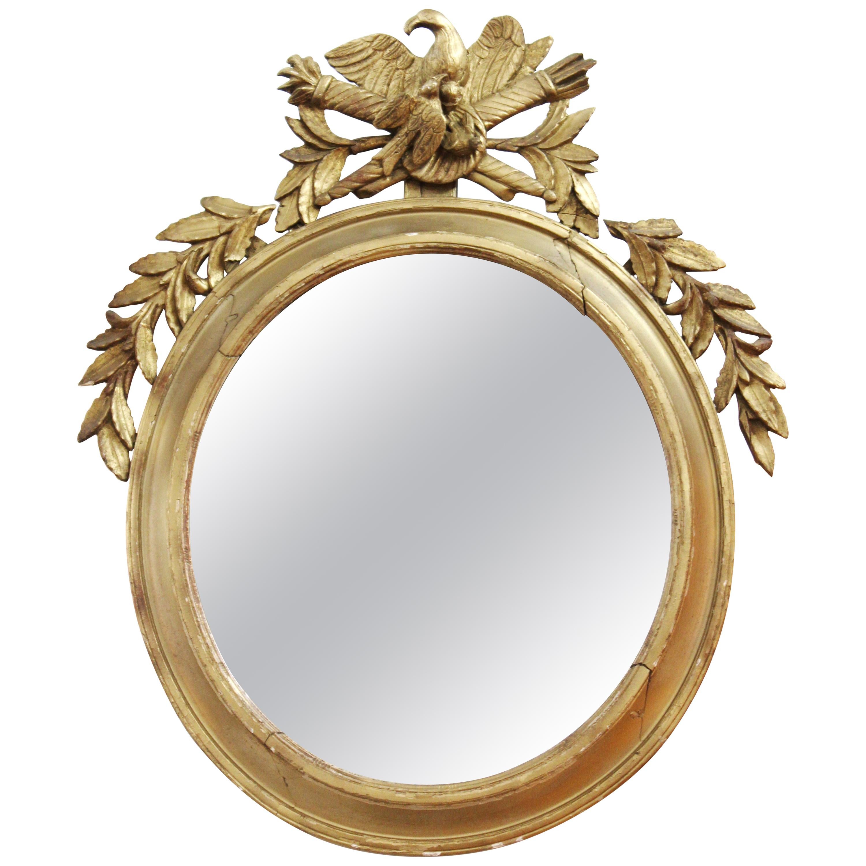 Miroir oblongue néoclassique en bois doré avec aigle et trophées en vente