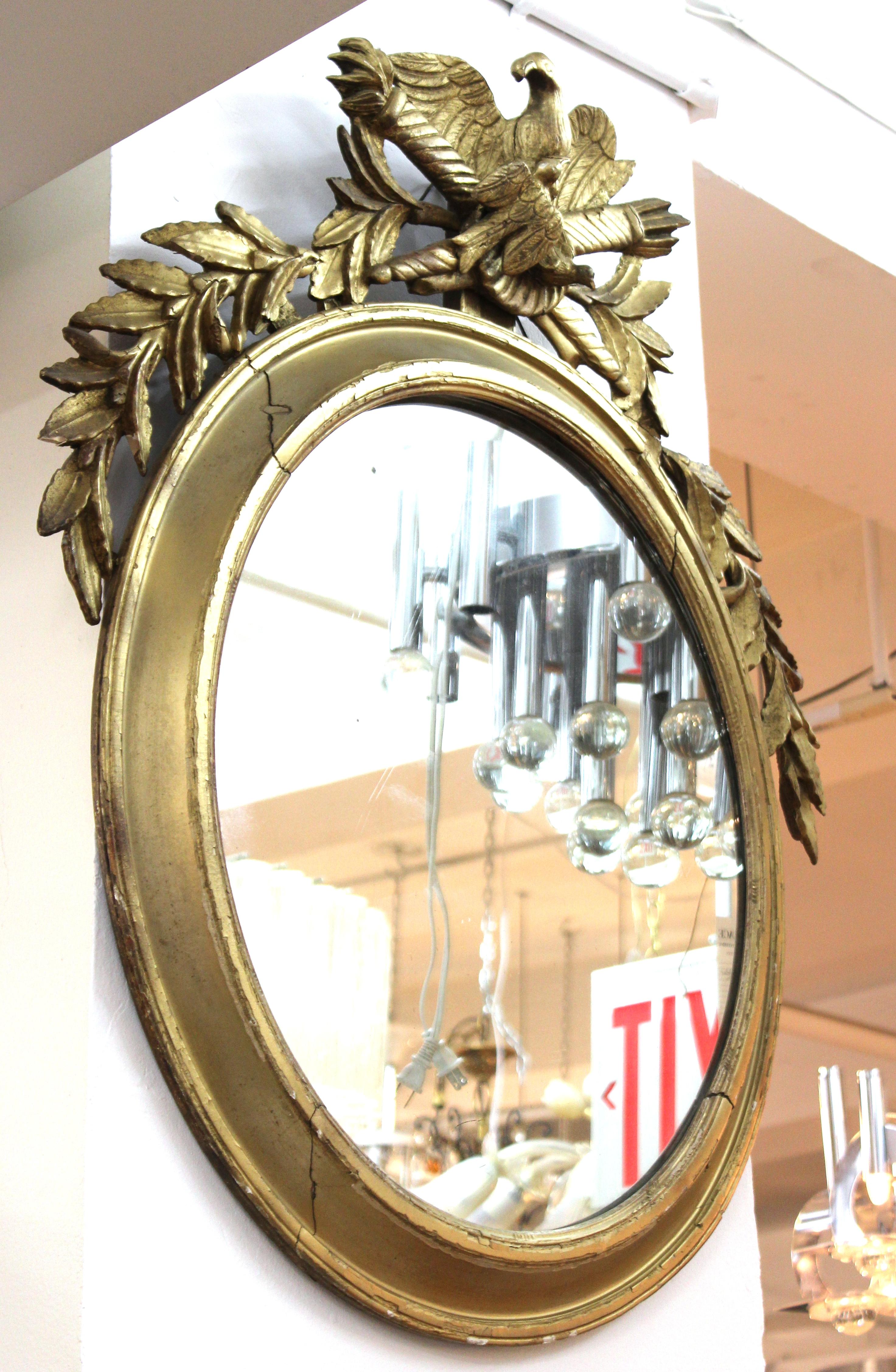 Miroir mural oblong néoclassique continental en bois doré. La pièce présente des trophées flanqués d'un aigle sur le dessus. Fabriqué au 19e siècle.

Concessionnaire : S138XX