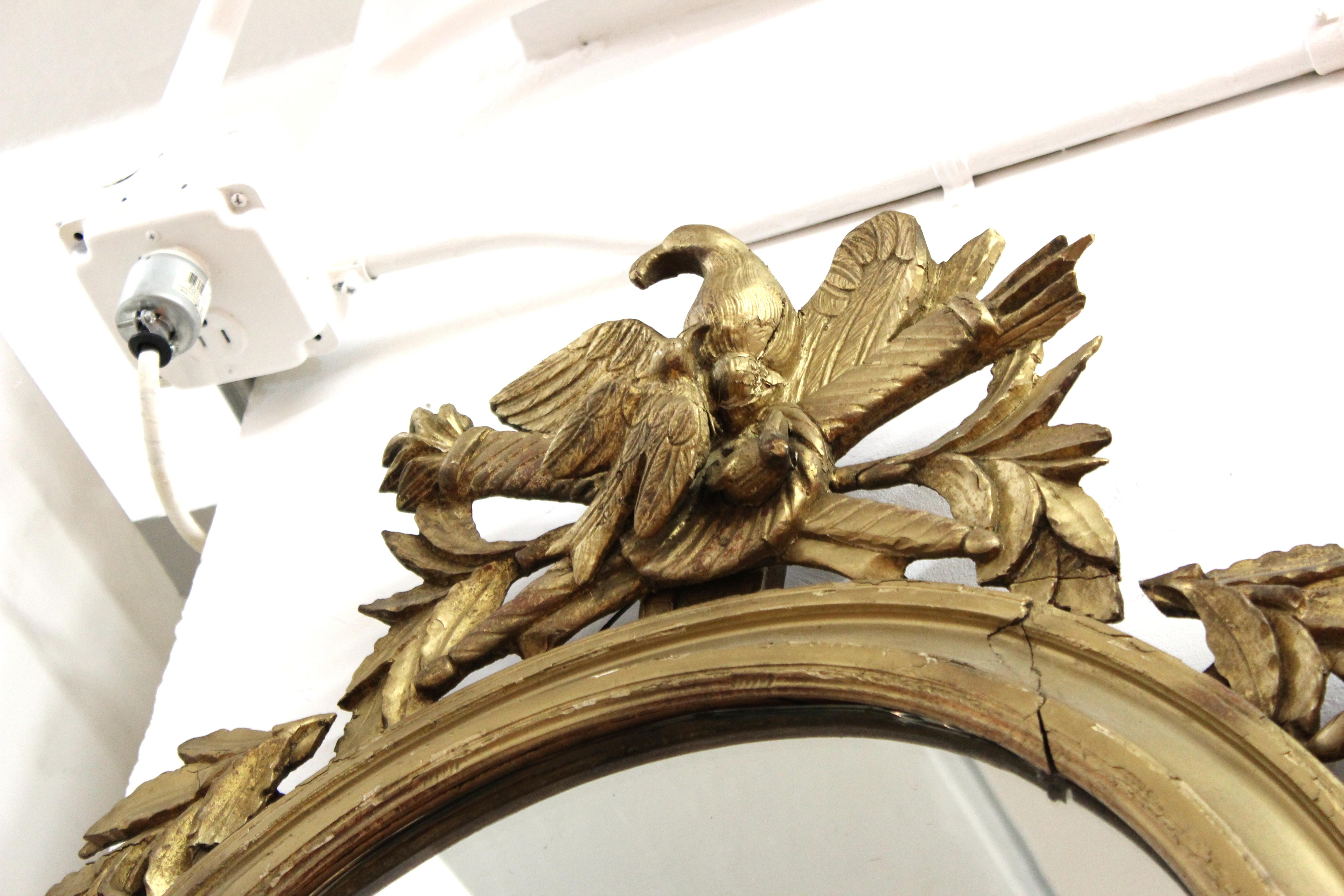 Européen Miroir oblongue néoclassique en bois doré avec aigle et trophées en vente