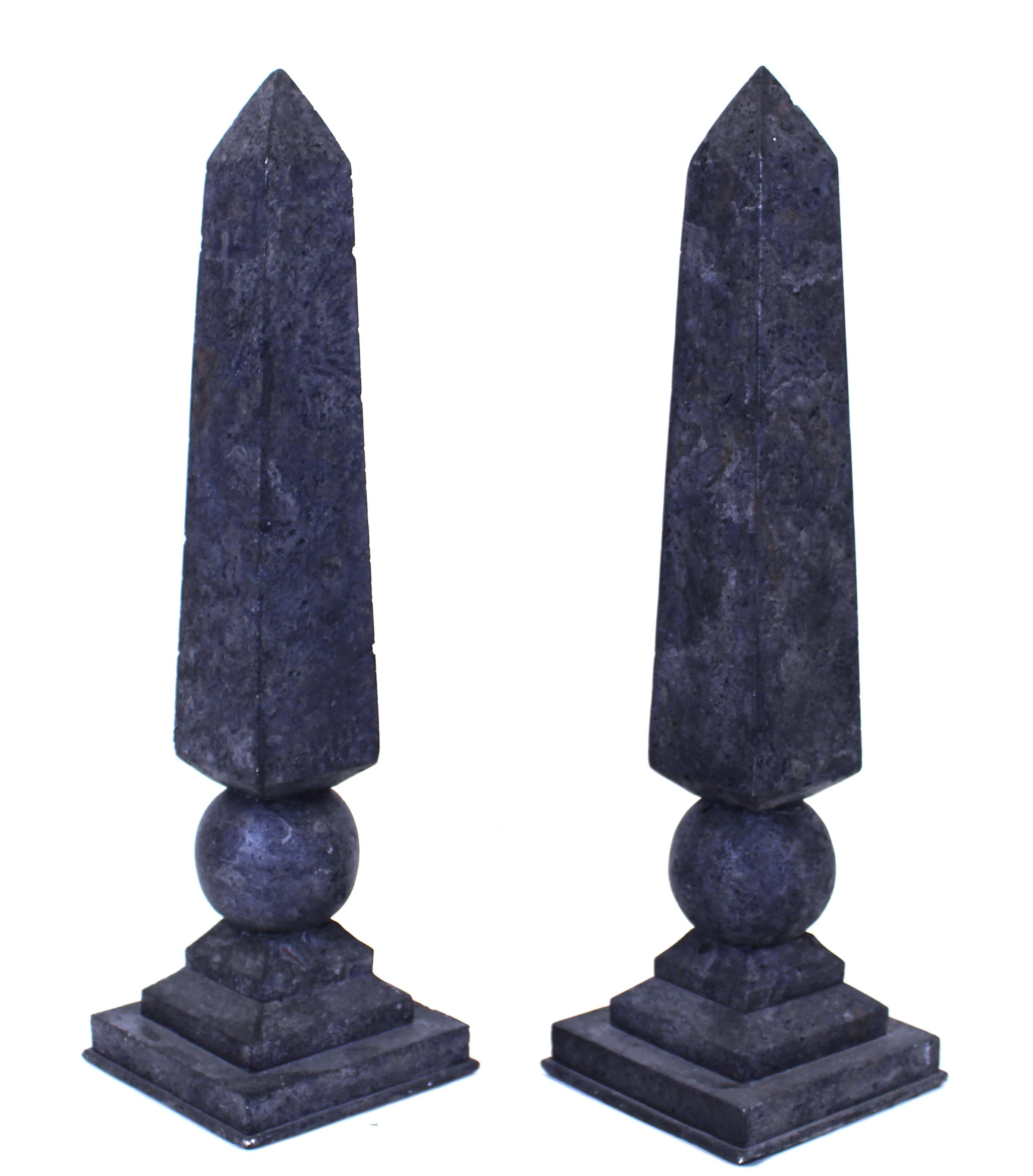 Neoclassical revival style pair of cast resin obelisks atop spheres and stepped square bases. Measures: 20